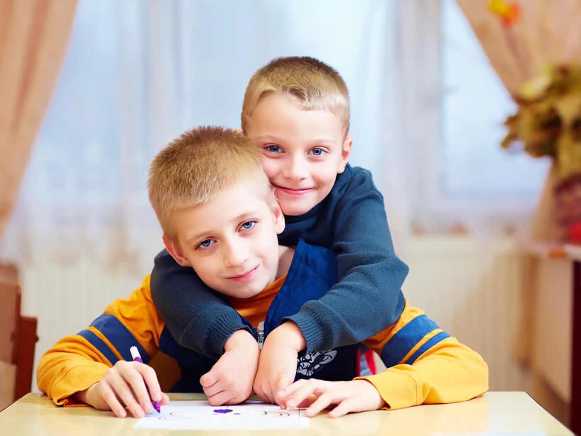 a couple of boys sitting at a table