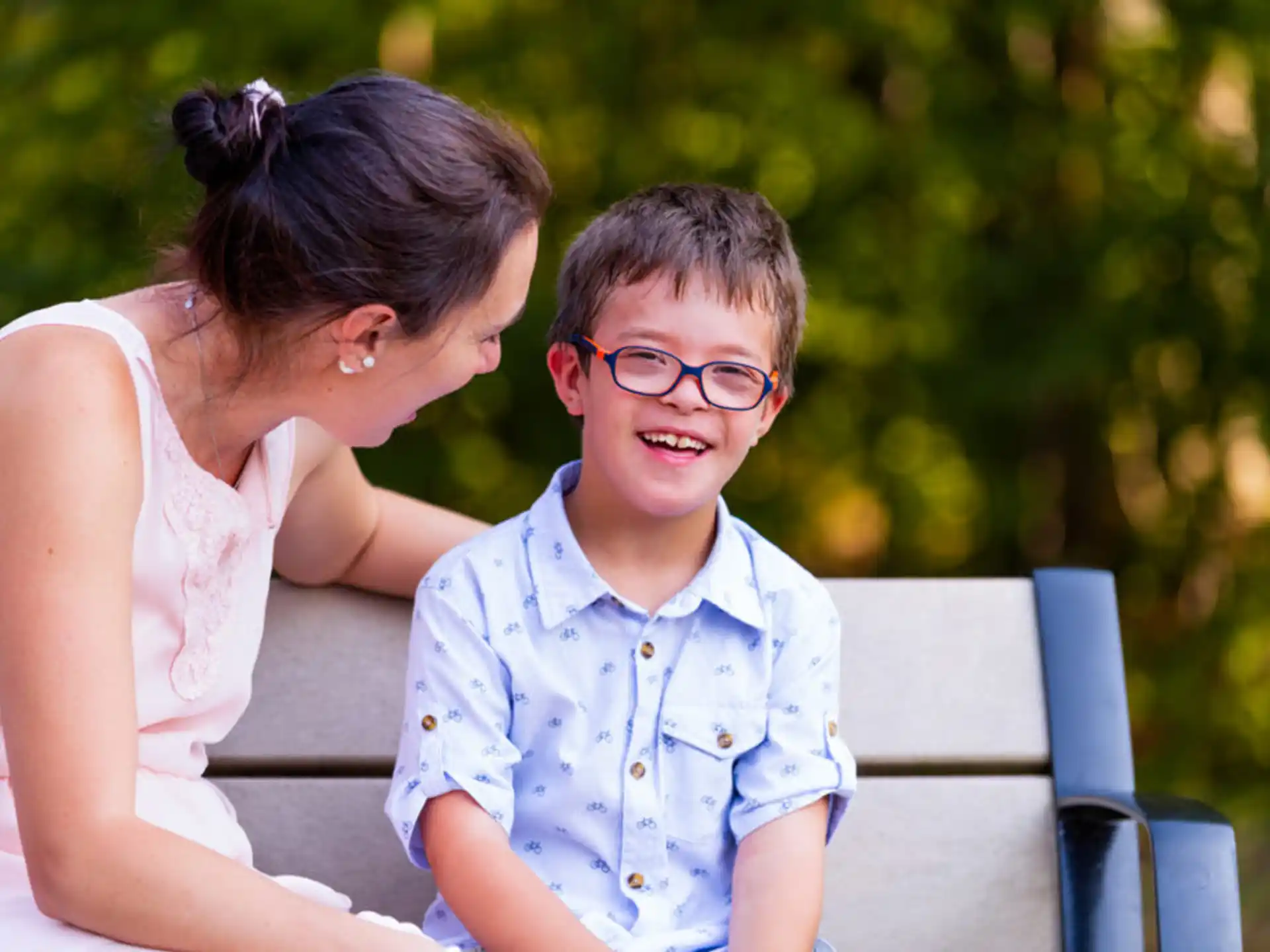 a person and a boy sitting on a bench