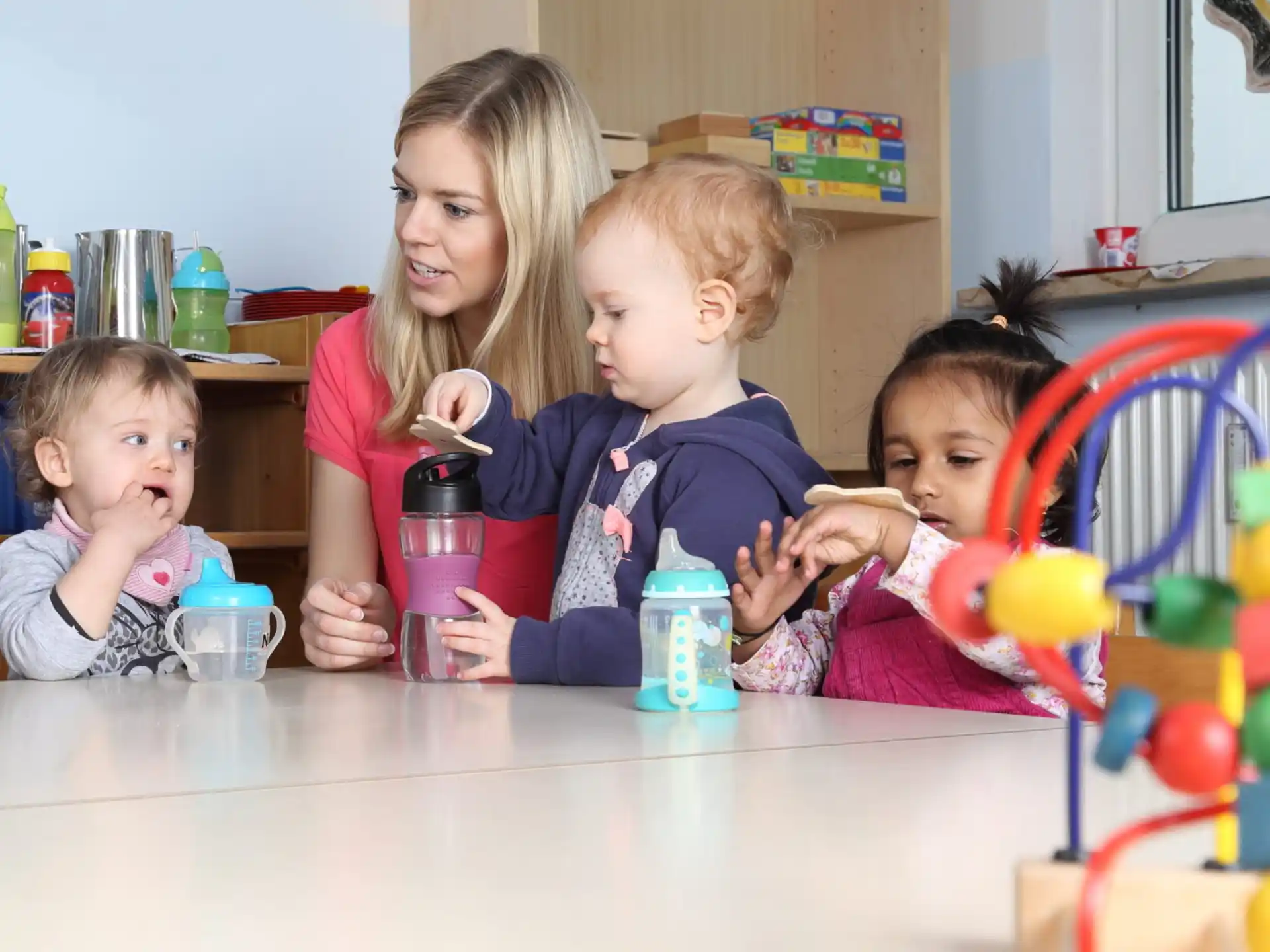 a person and two children sitting at a table with a toy