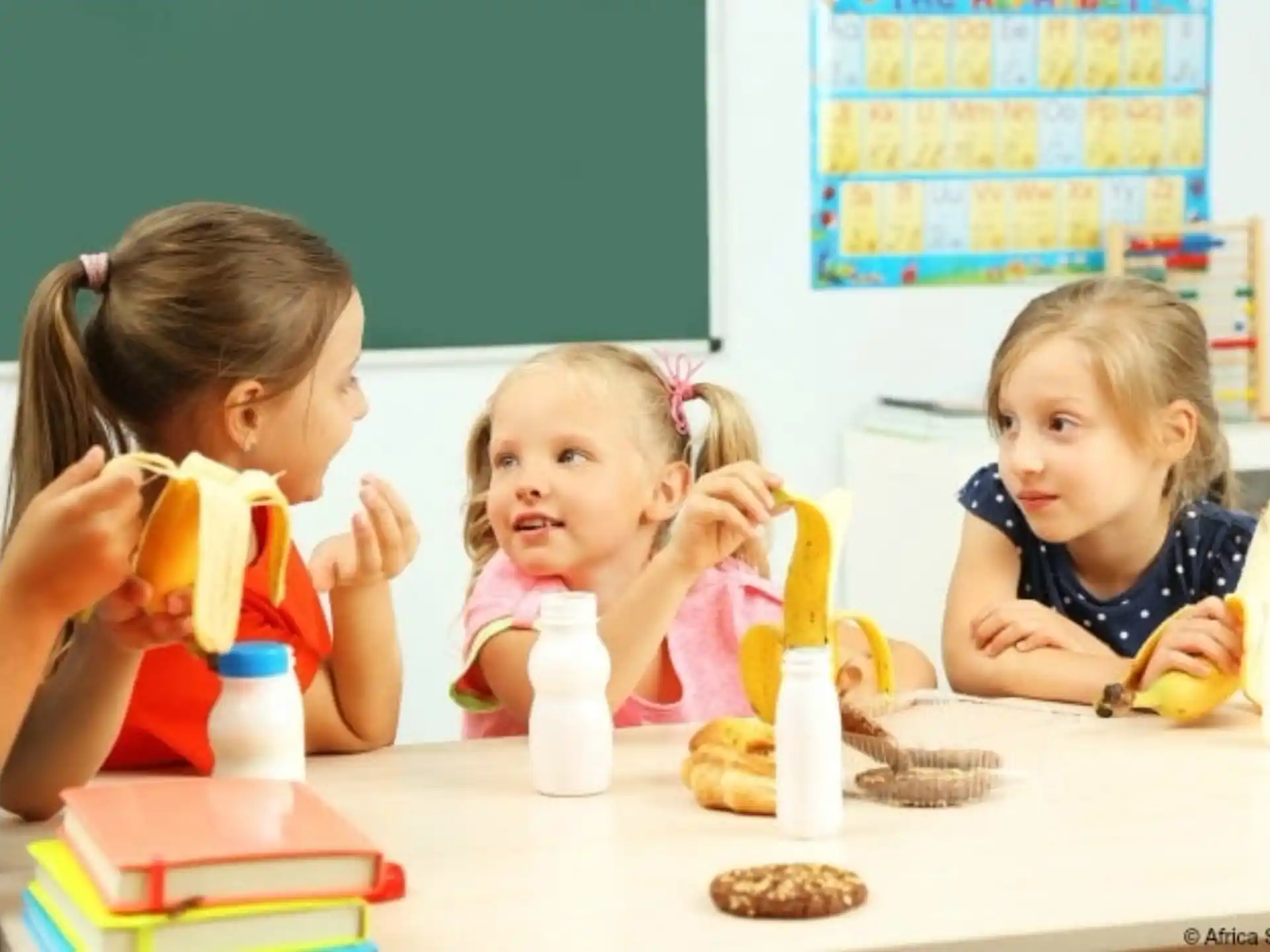 a group of children eating at a table