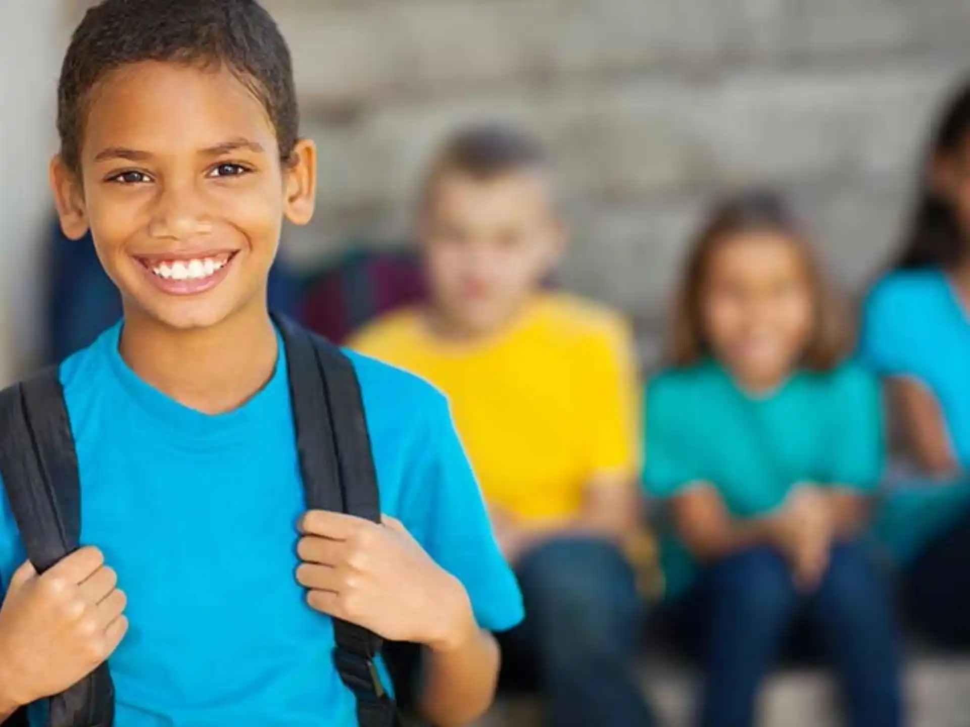 a young boy carrying a backpack