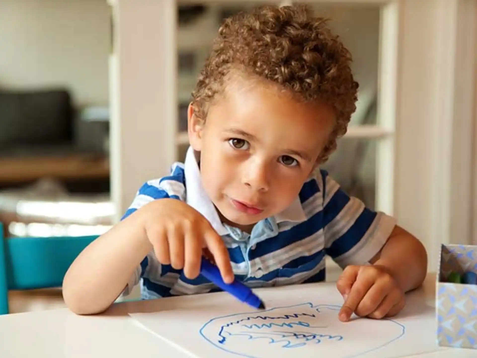 a young boy coloring on a paper