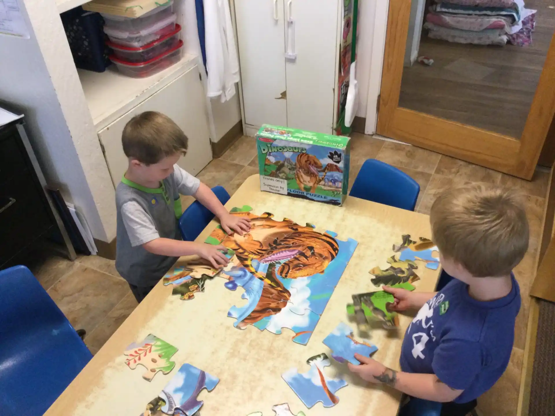 a couple of boys playing with toys on a table