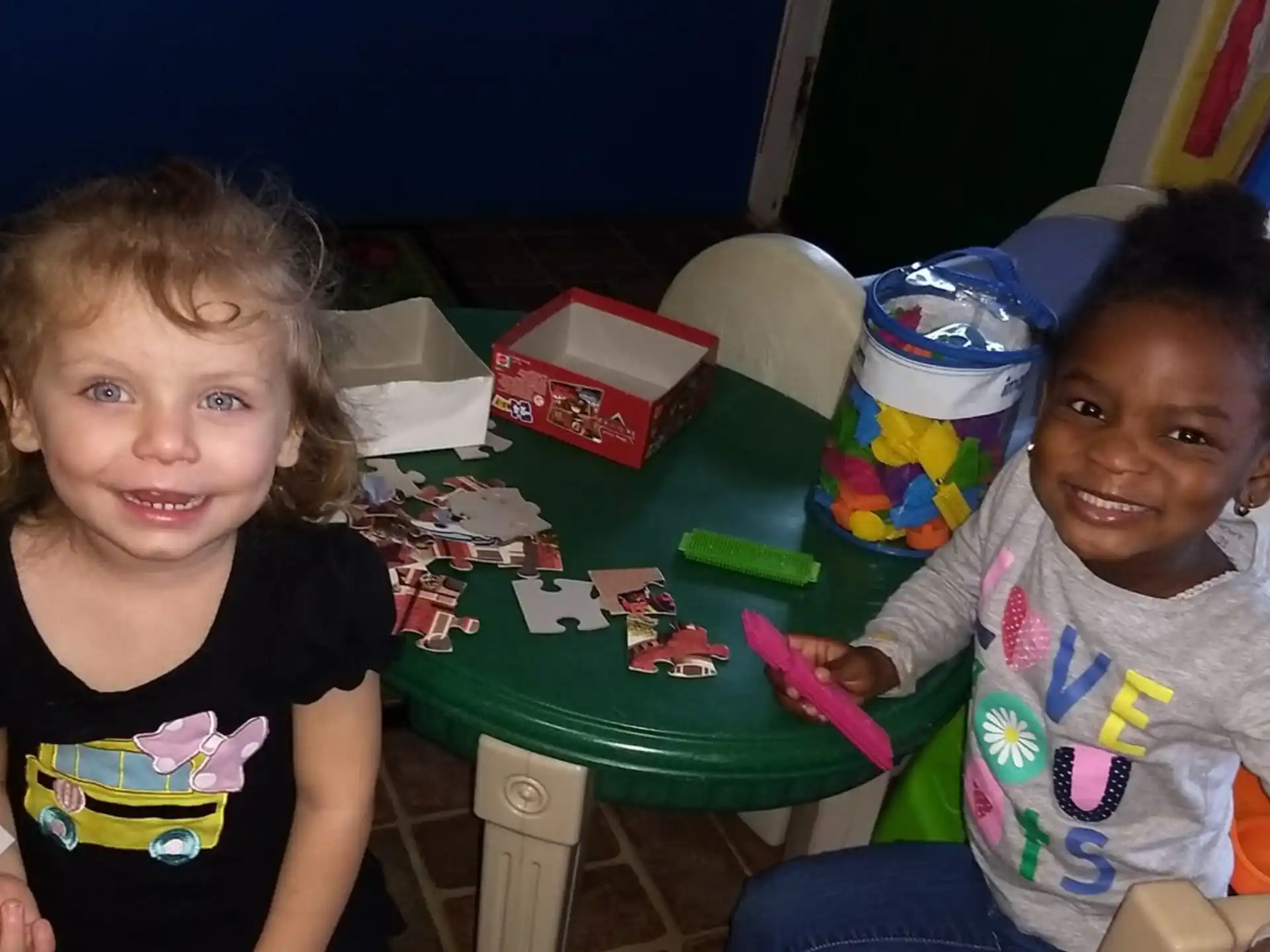 a couple of children sitting at a table with toys
