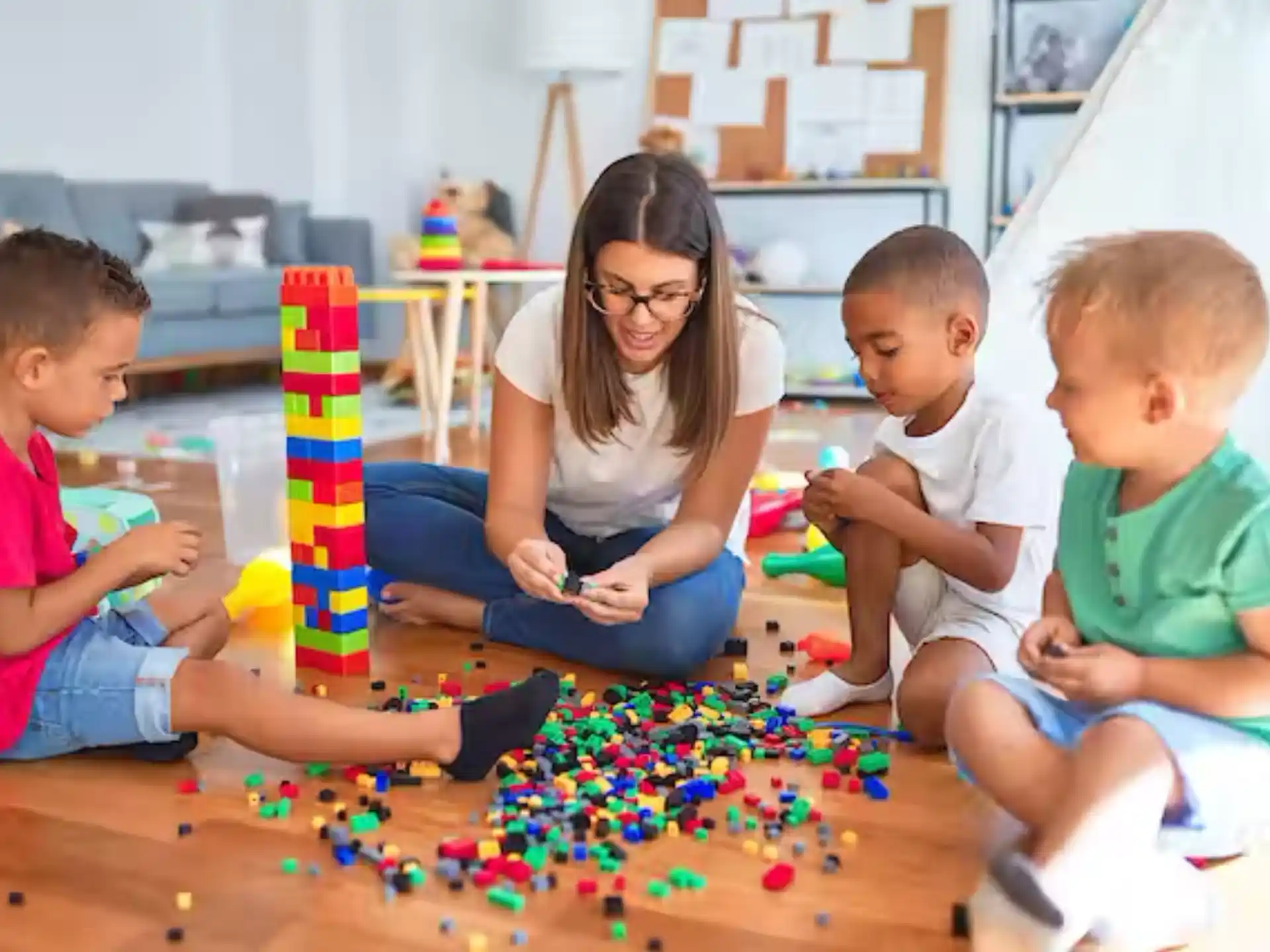 a person and several children playing with toys on the floor