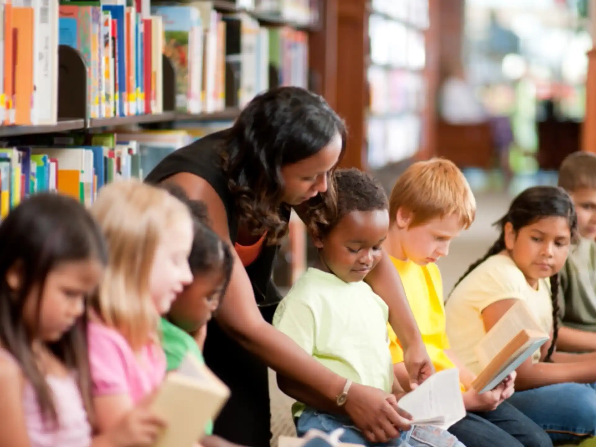 a person reading a book to a group of children