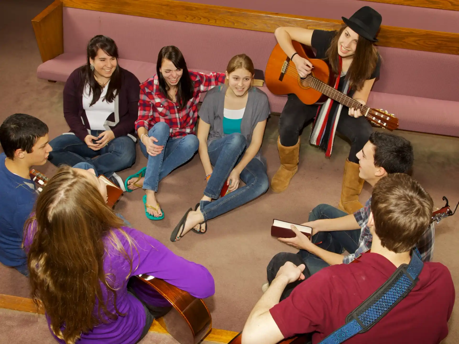 a group of people sitting on the floor playing instruments