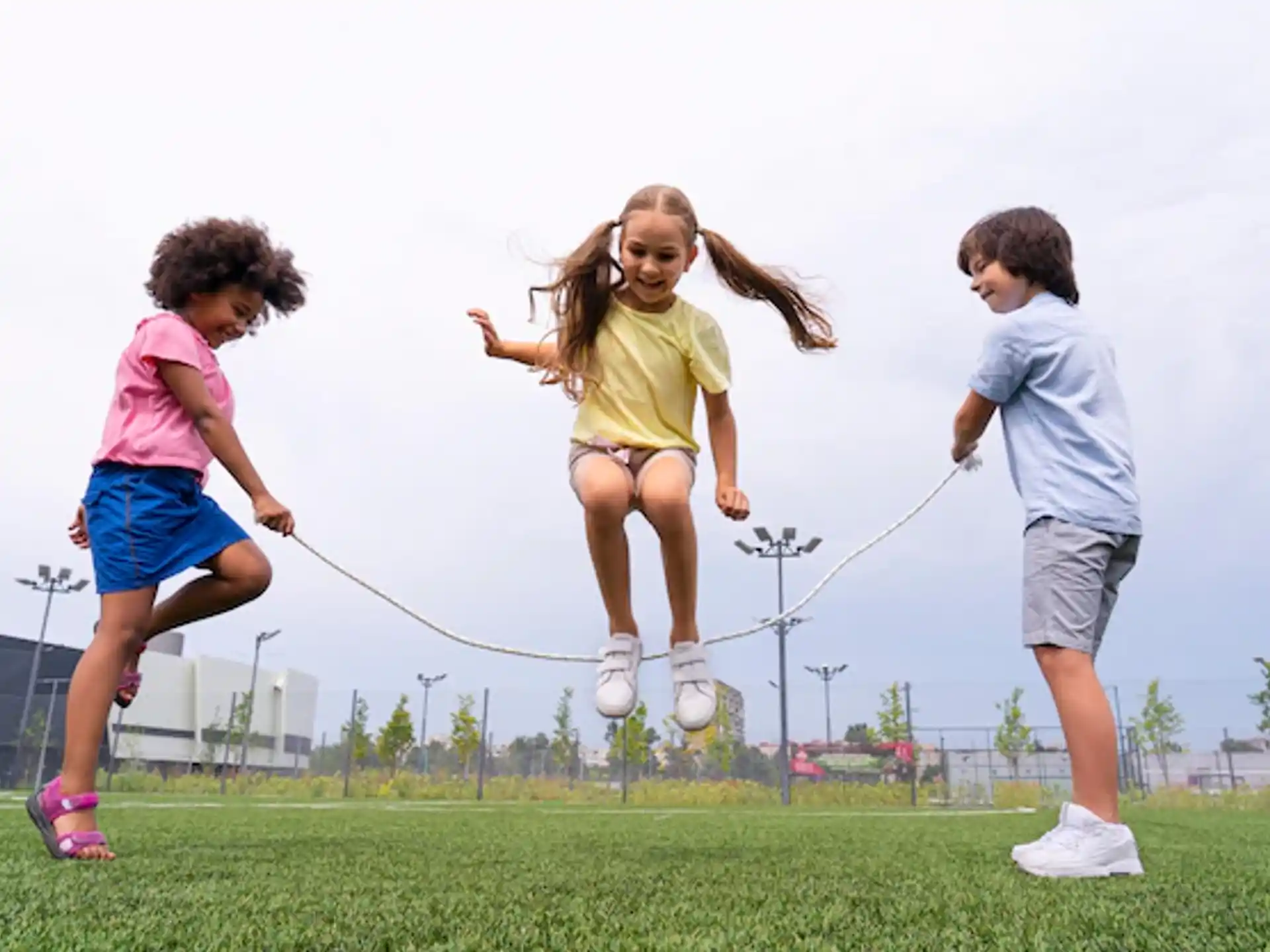 a group of kids running on a grass field