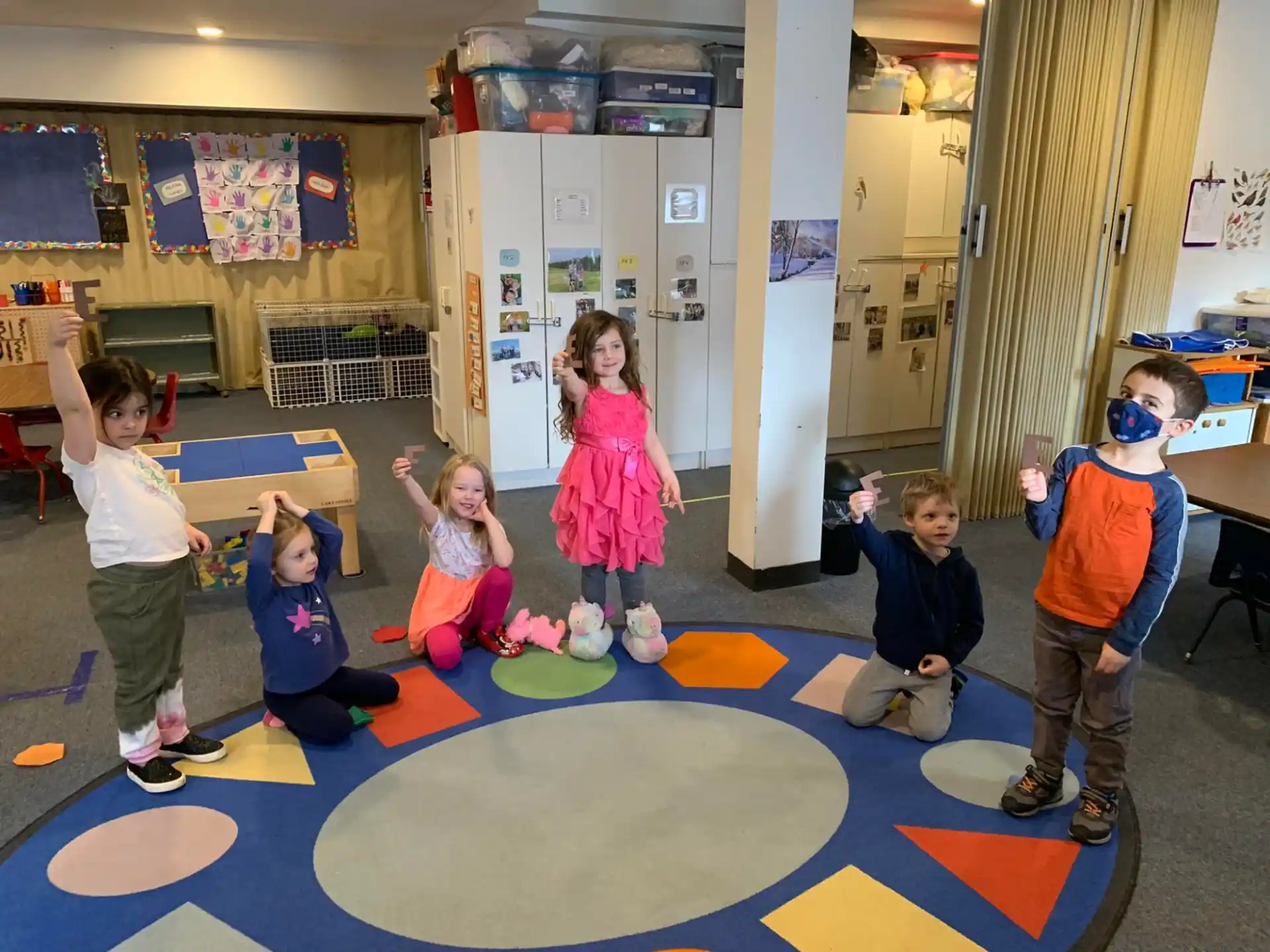 a group of children playing on a mat in a room