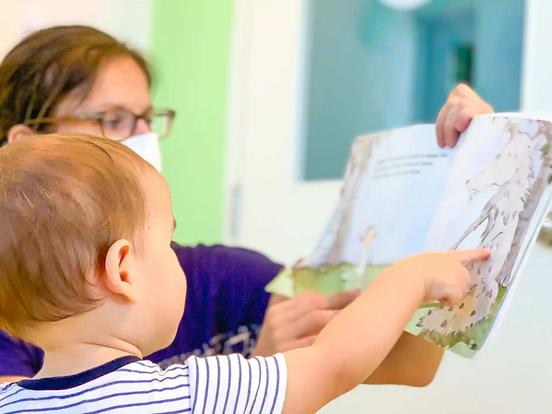 a person reading a book to a young boy
