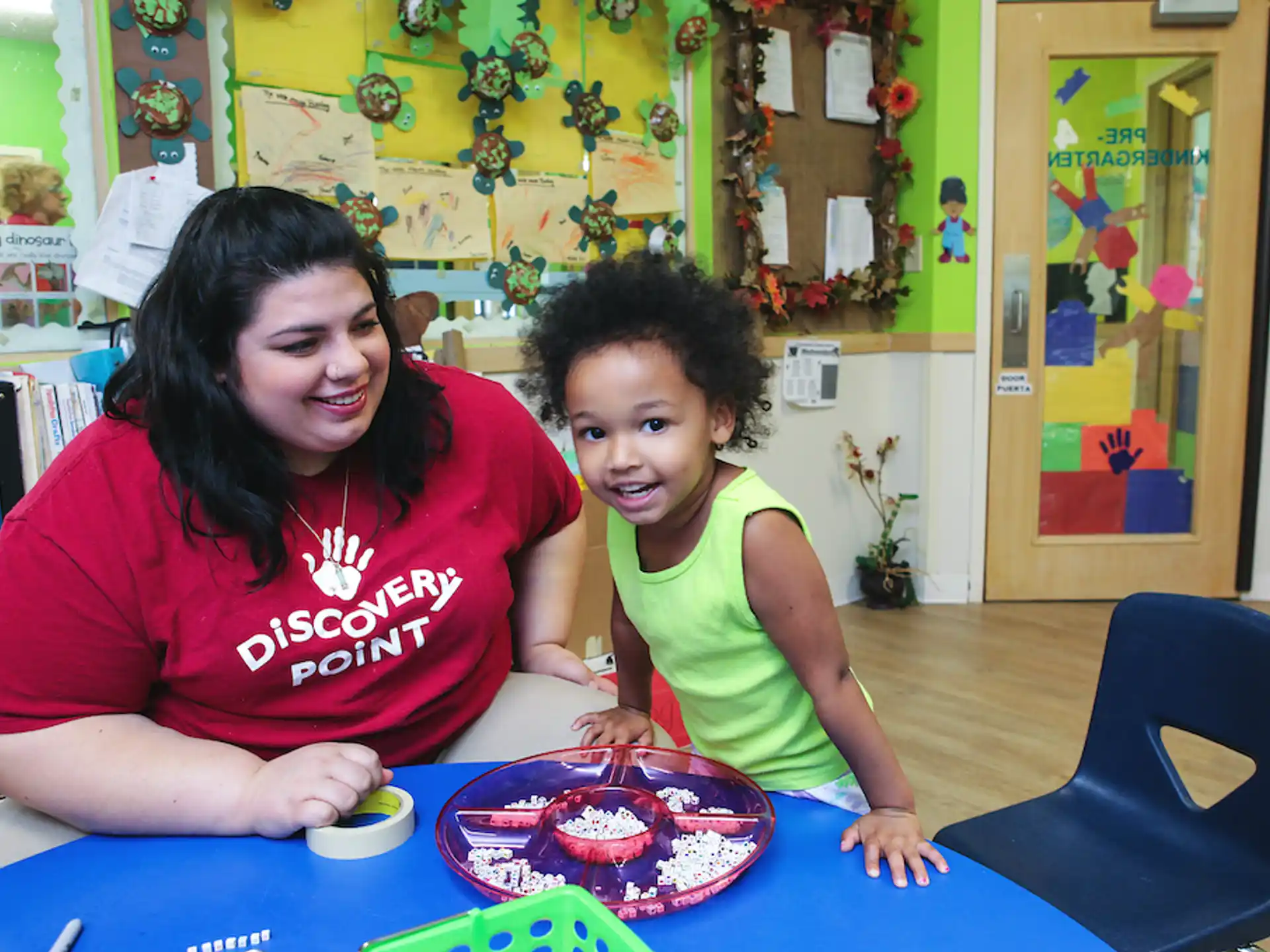 a person and a child sitting at a table with a cake