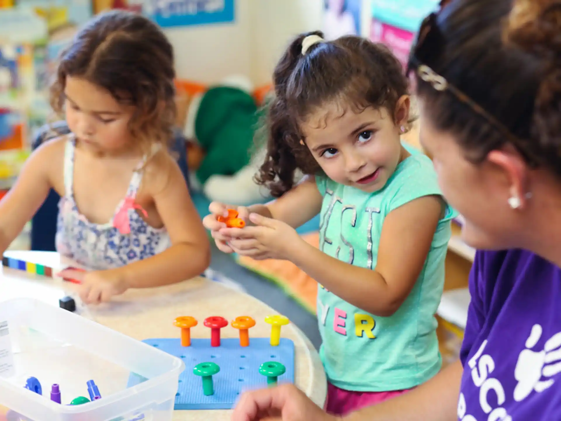 a person and a couple of children playing with toys