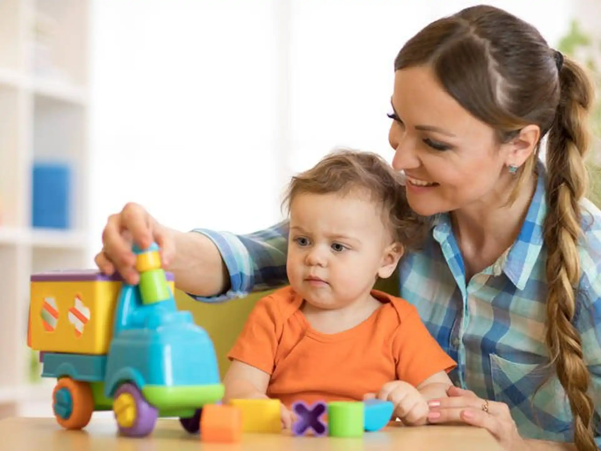 a person and a baby playing with toys