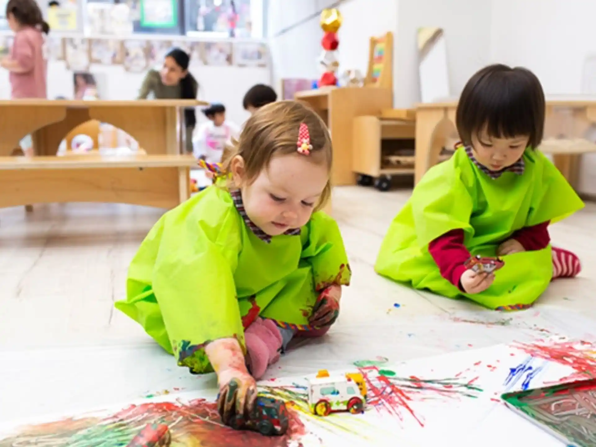 a couple of young girls playing on the floor
