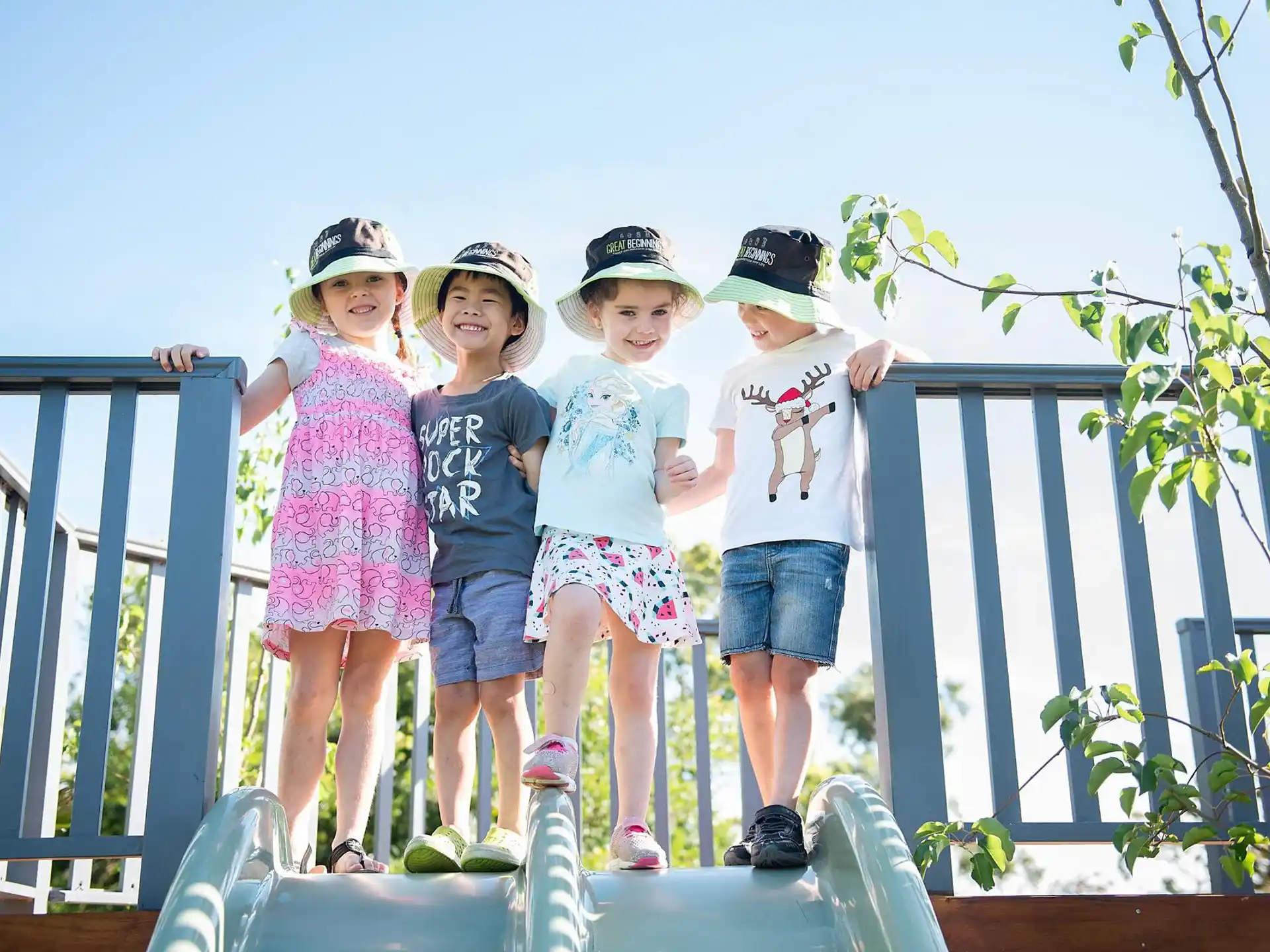 a group of children posing for a photo on a bridge