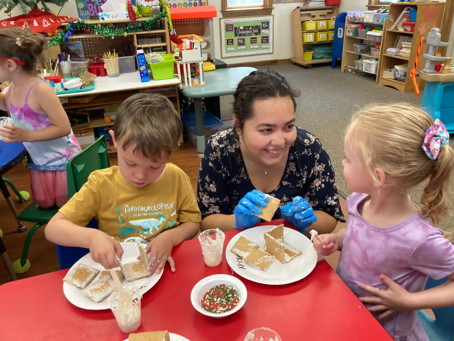 a person and two children sitting at a table with food