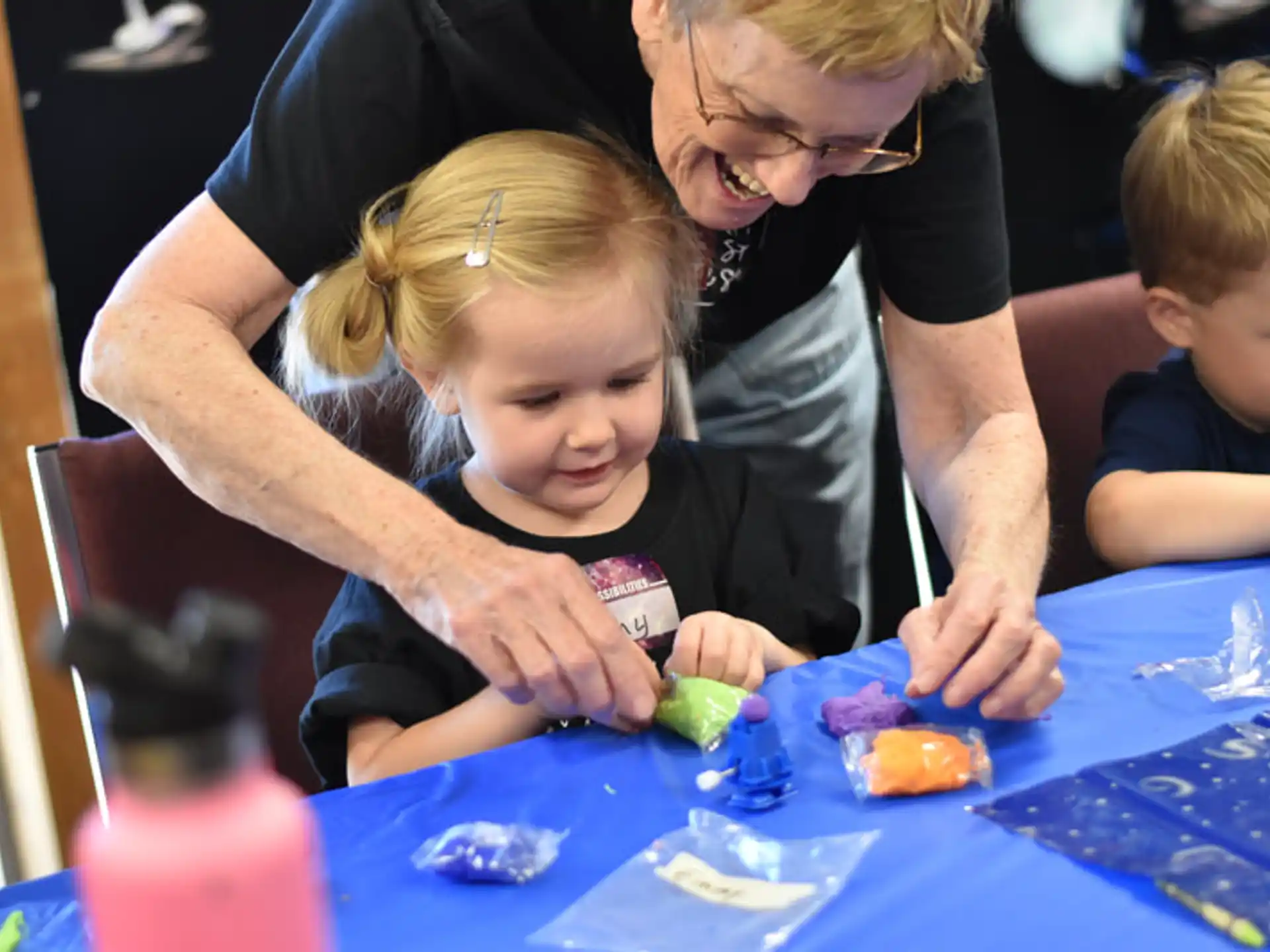 a person and a couple of children playing with toys