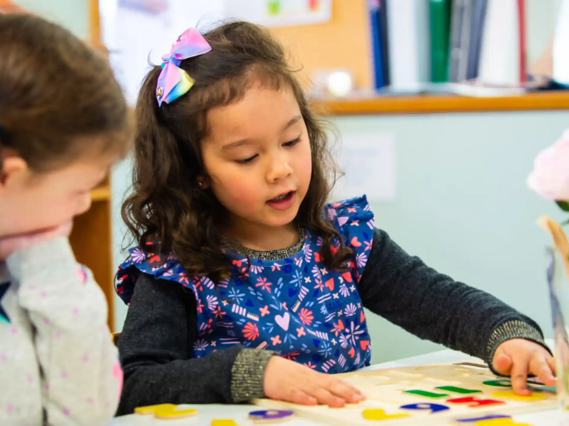a young girl and a young girl coloring on a paper