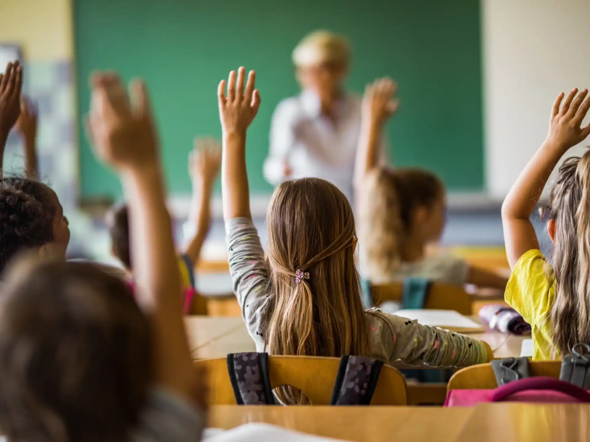 a group of children raising their hands