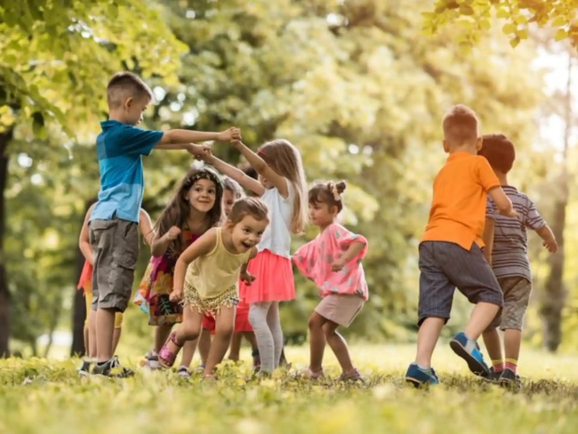 a group of children running in a park