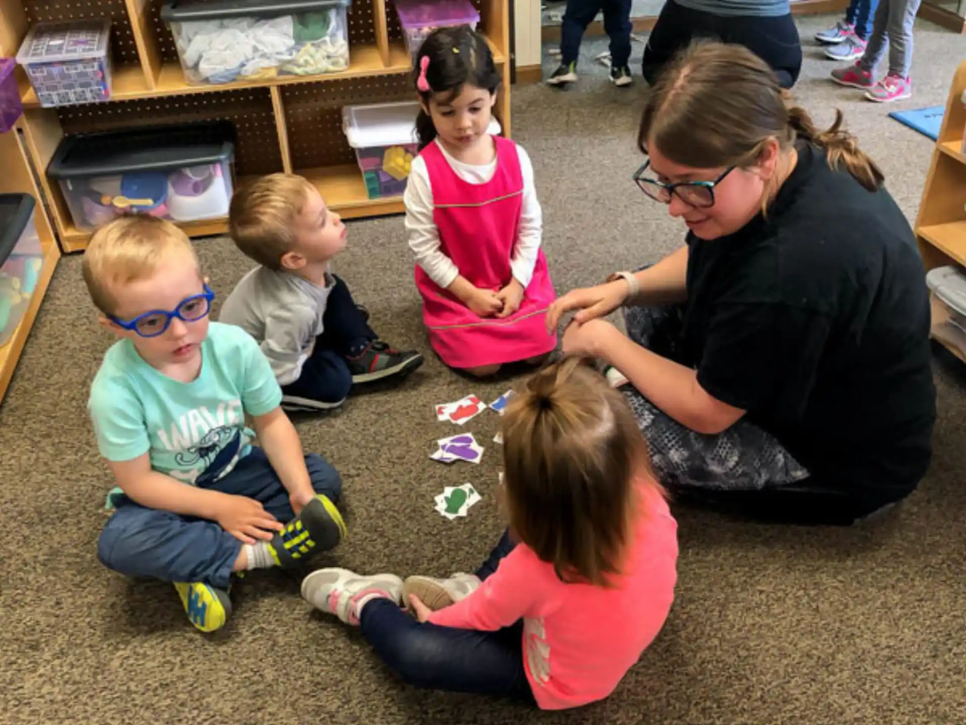 a person and several children sitting on the floor