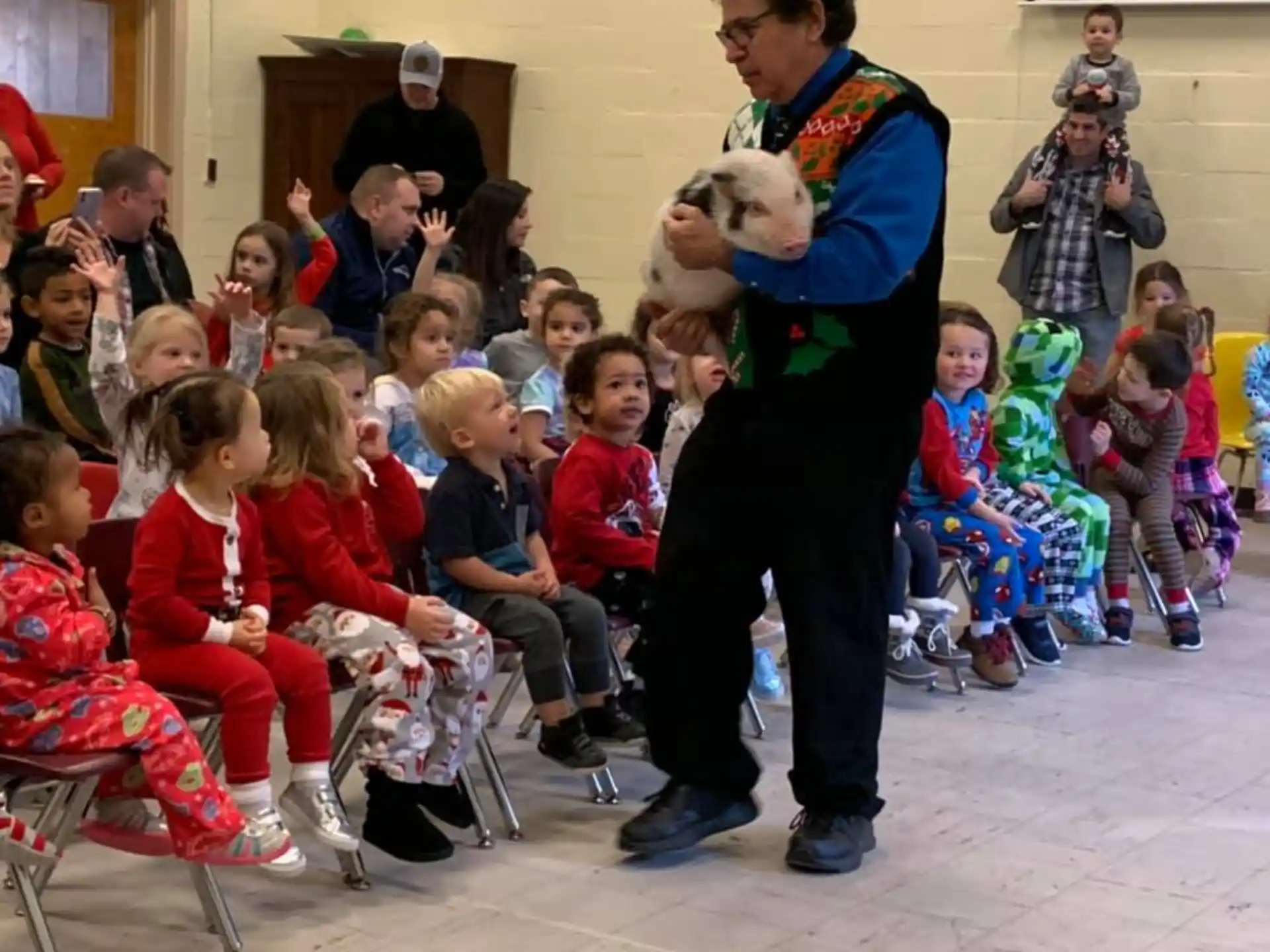 a person holding a teddy bear in front of a group of children