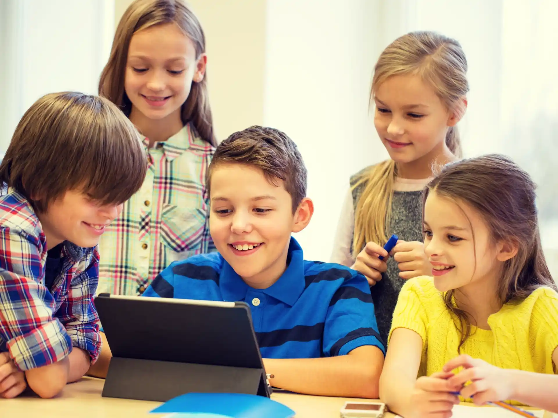 a group of children looking at a laptop