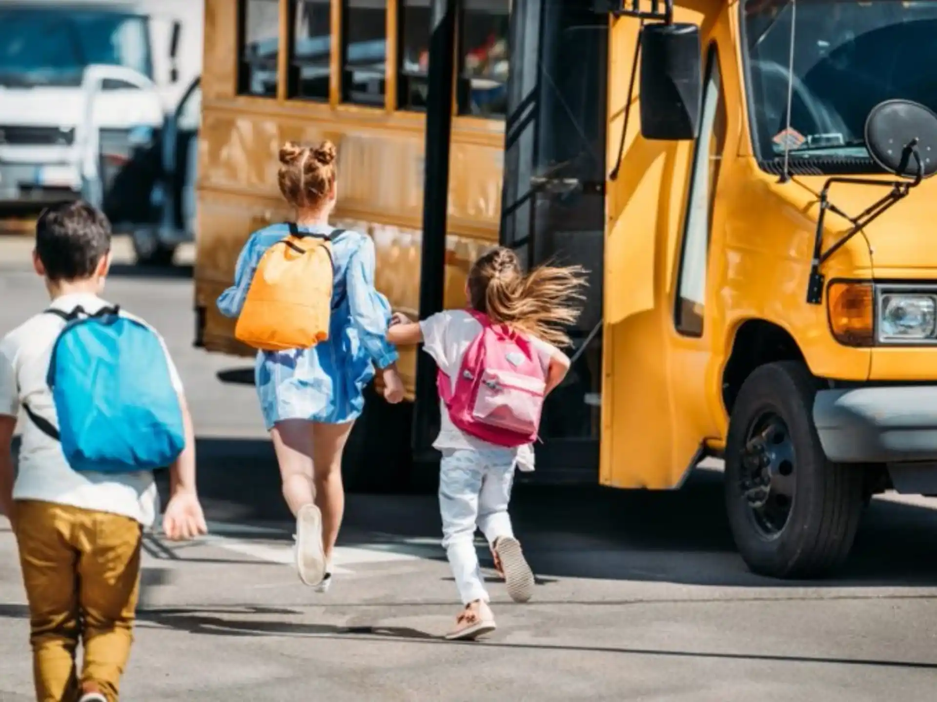 a group of people walking towards a school bus