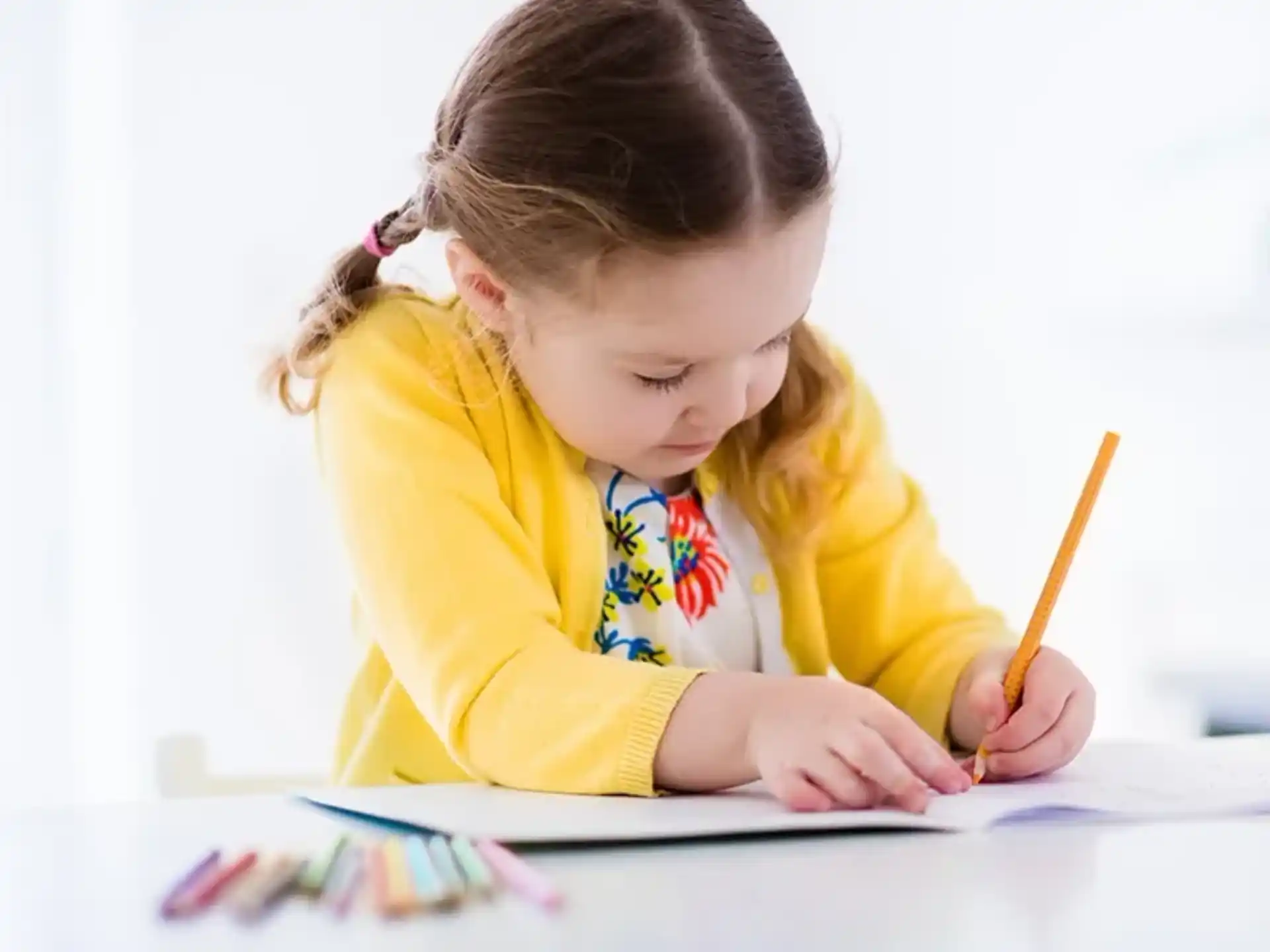 a young girl writing on a piece of paper
