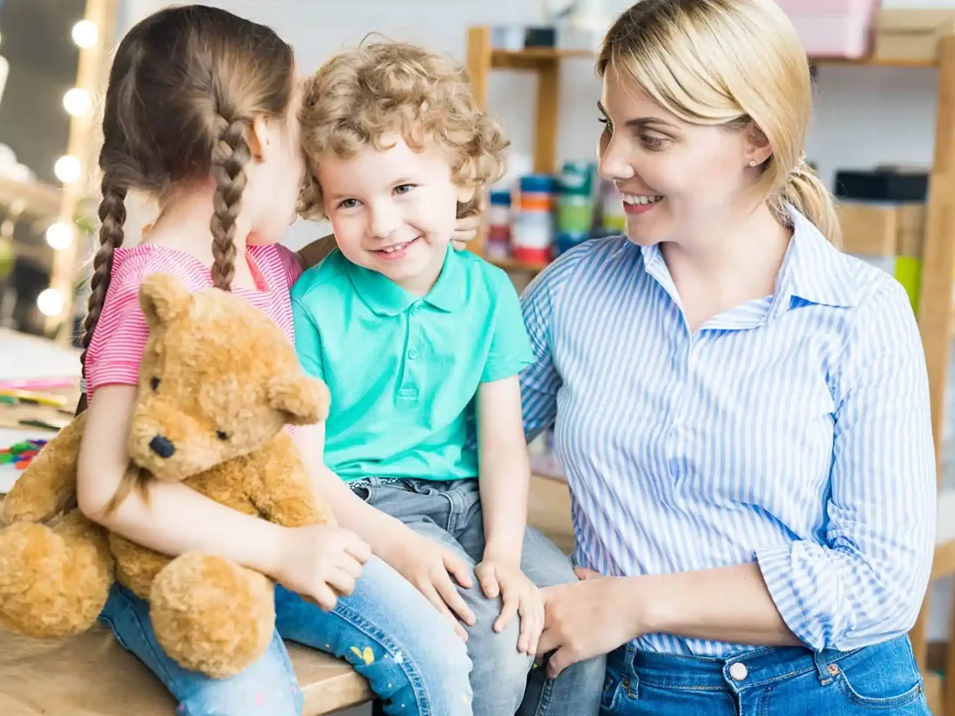 a person and a couple of children holding a teddy bear