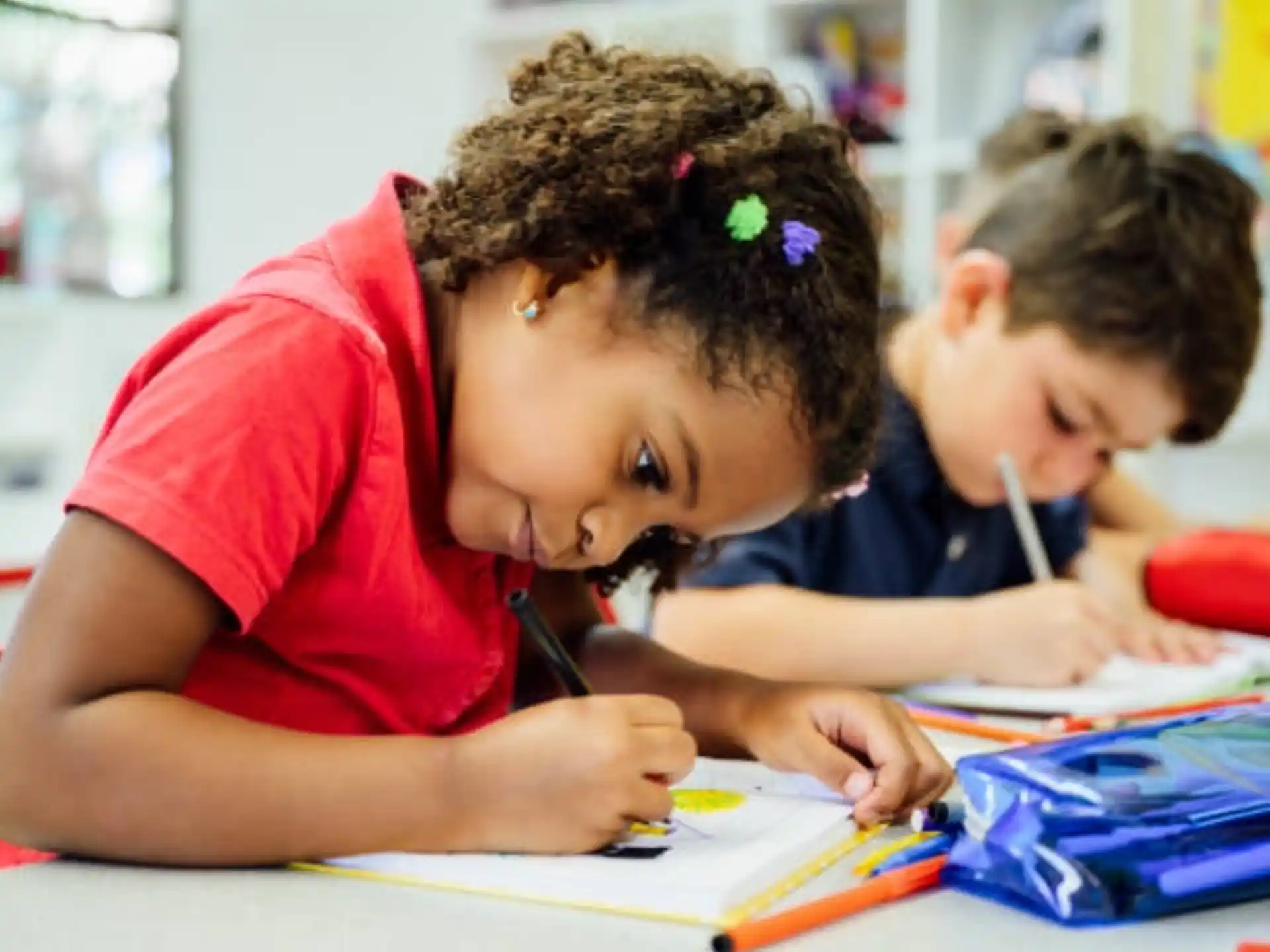 a young girl writing on a piece of paper