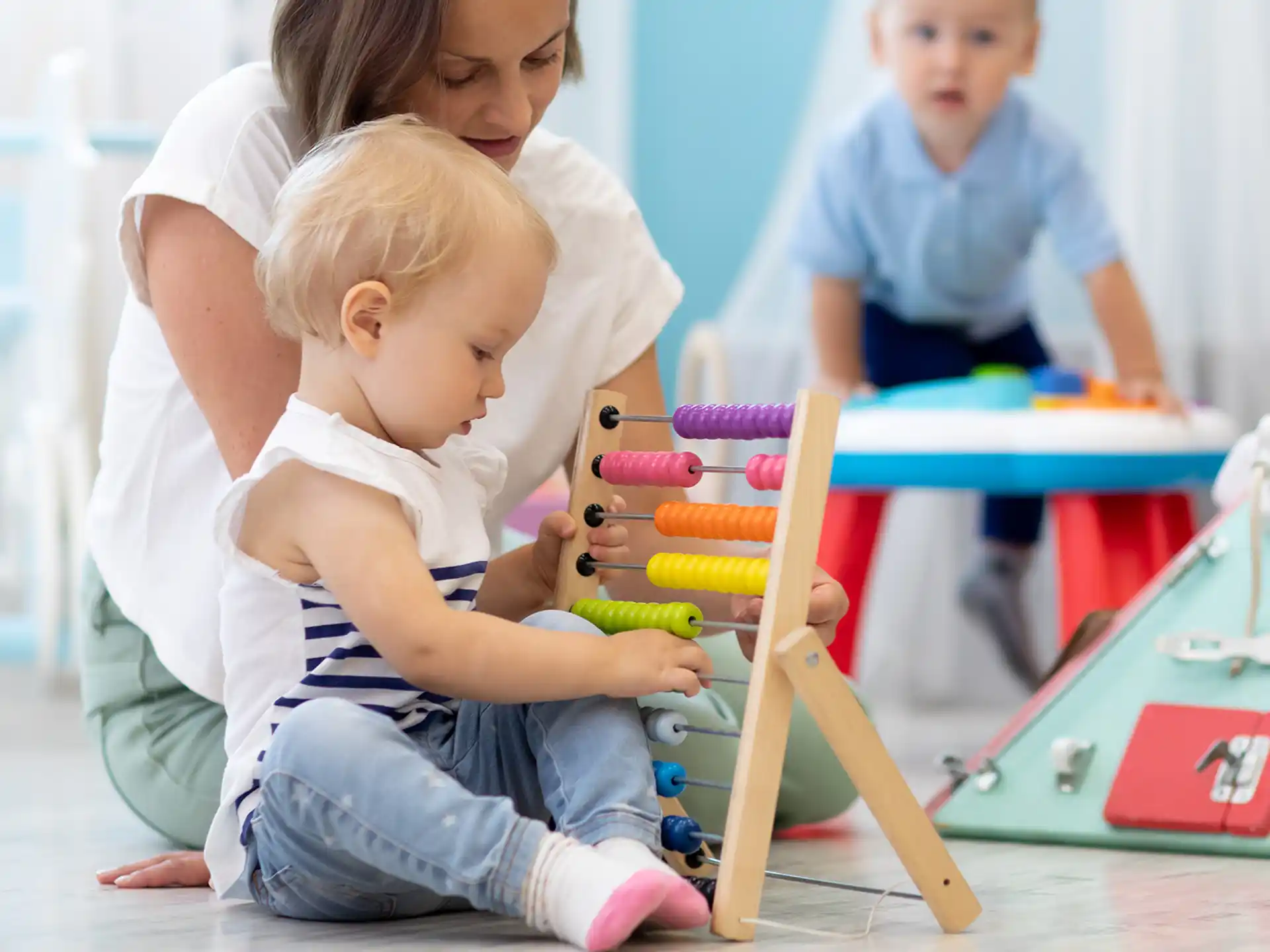 a person and a baby playing with toys