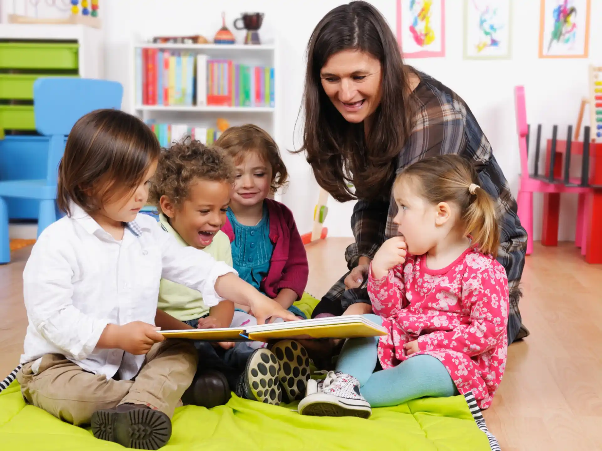 a person and several children sitting on a mat