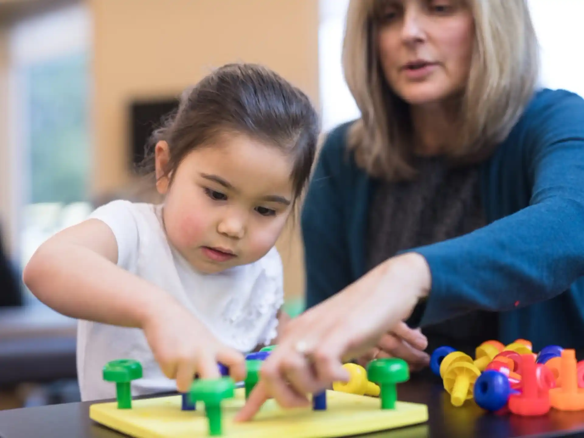 a woman and a child playing with toys
