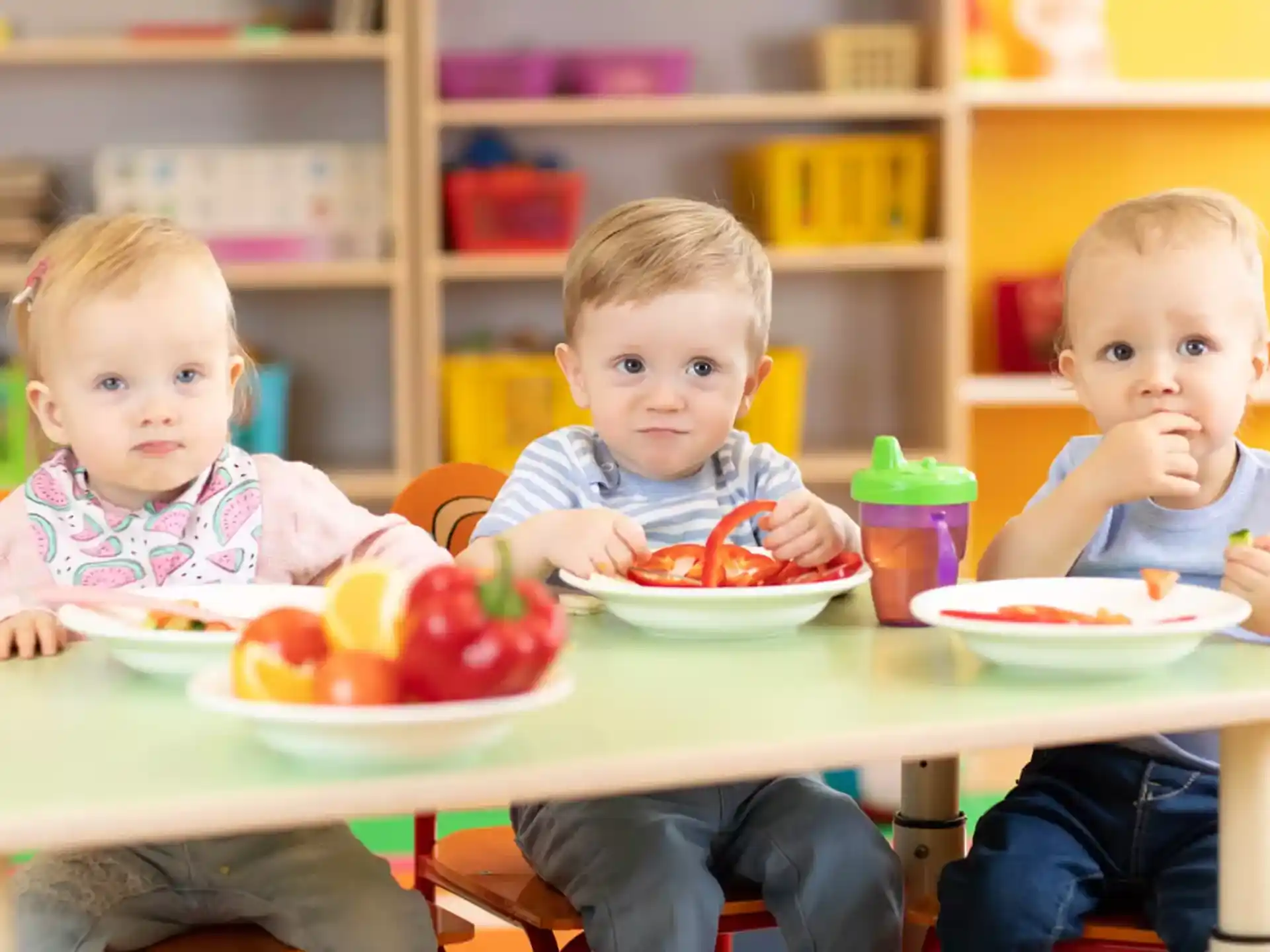 a group of kids eating at a table
