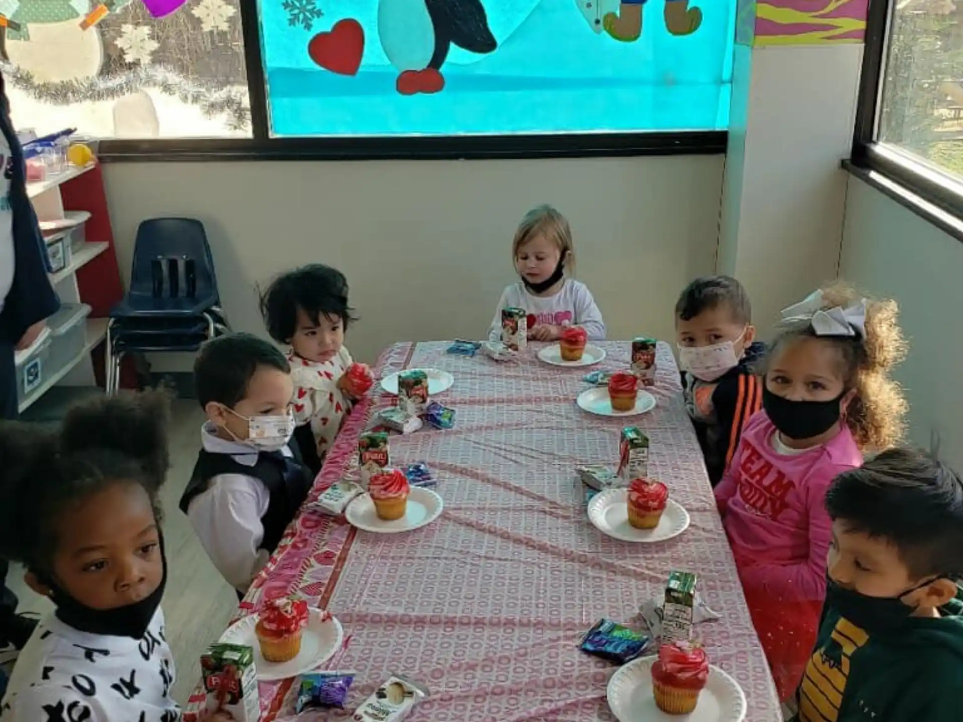 a group of children sitting at a table eating food