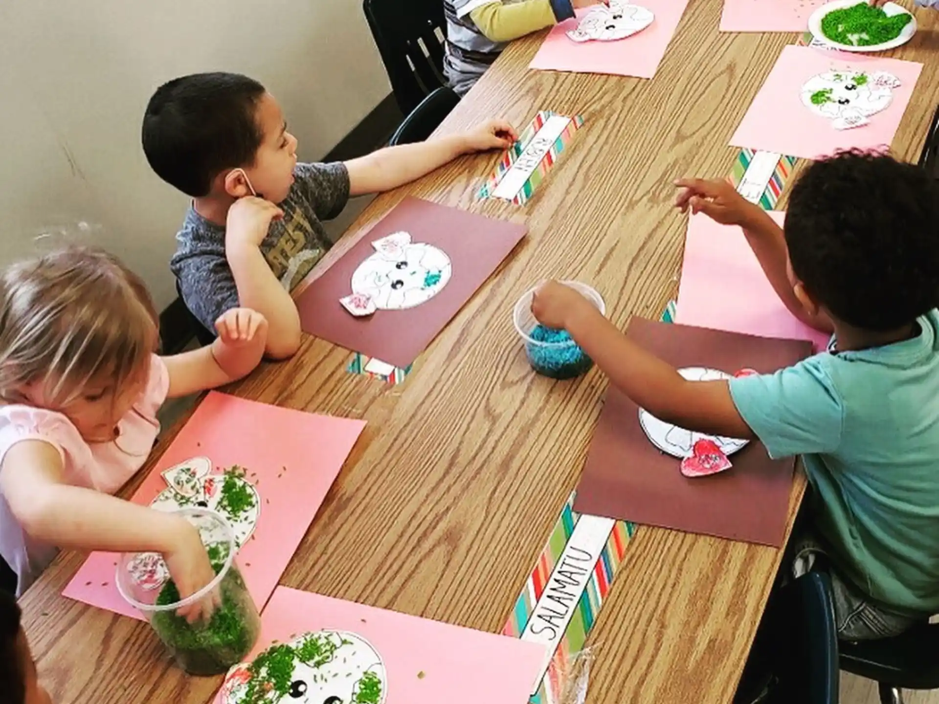 a group of children sitting at a table eating food