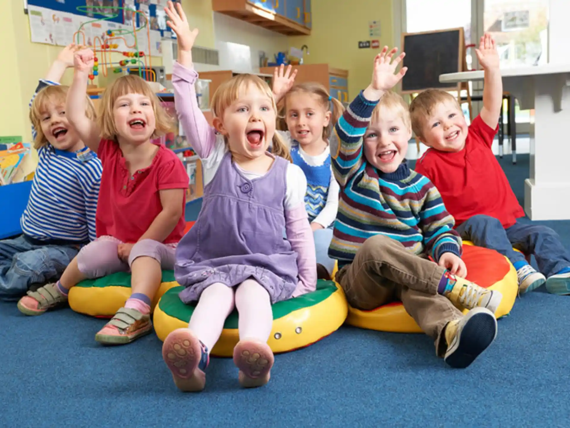 a group of children sitting on a green and yellow toy