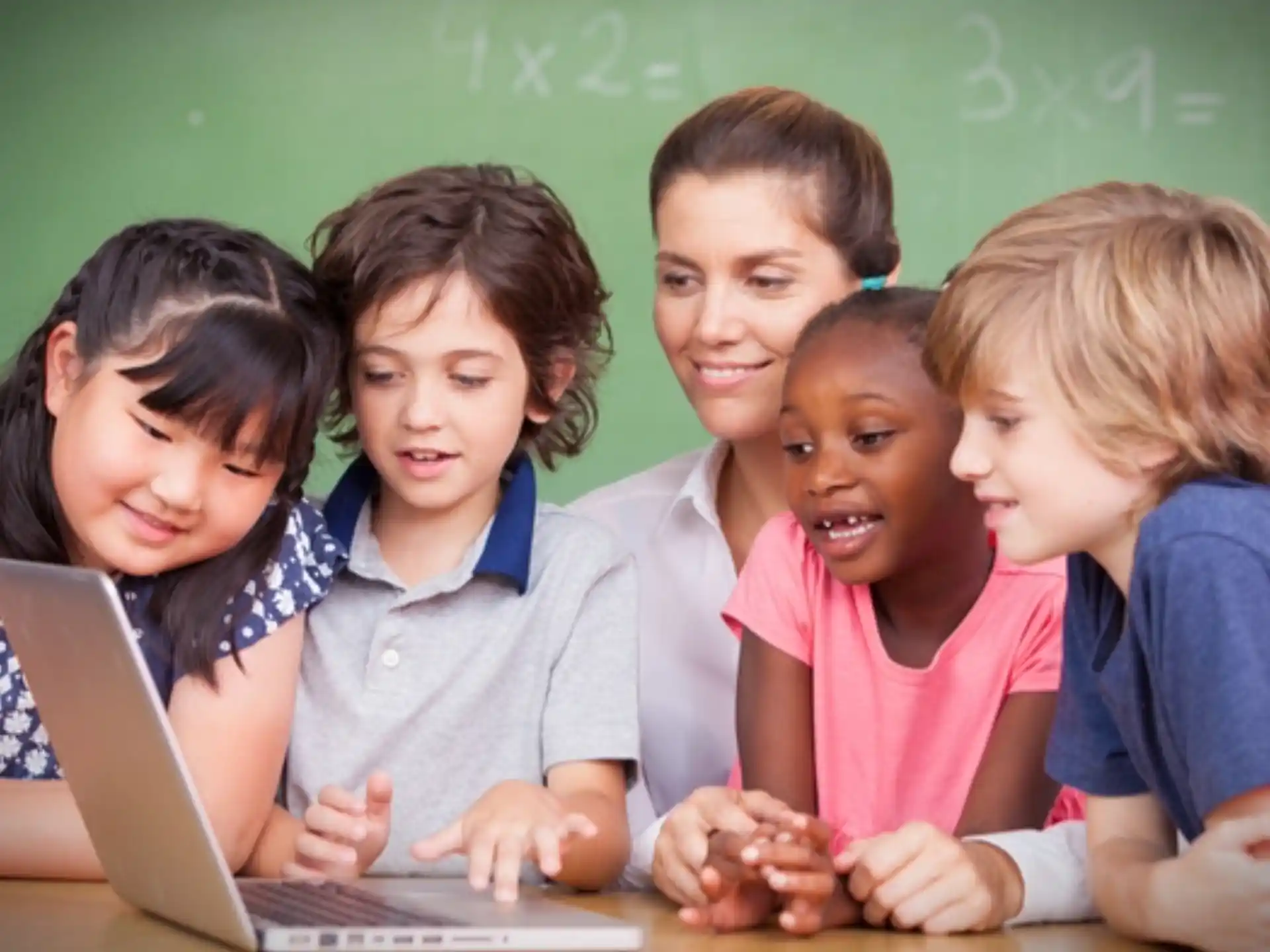 a group of children looking at a laptop