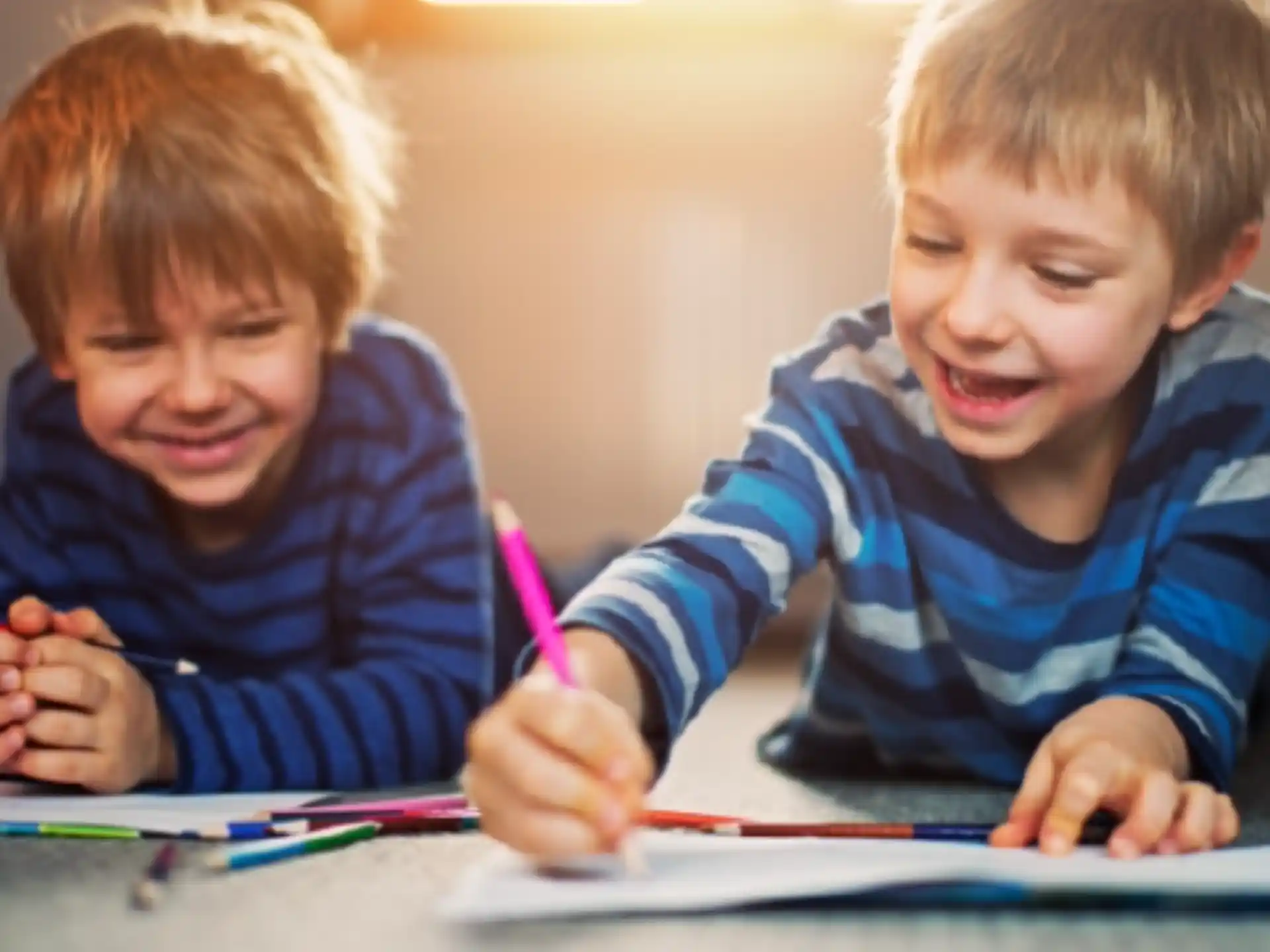 a couple of boys coloring on paper