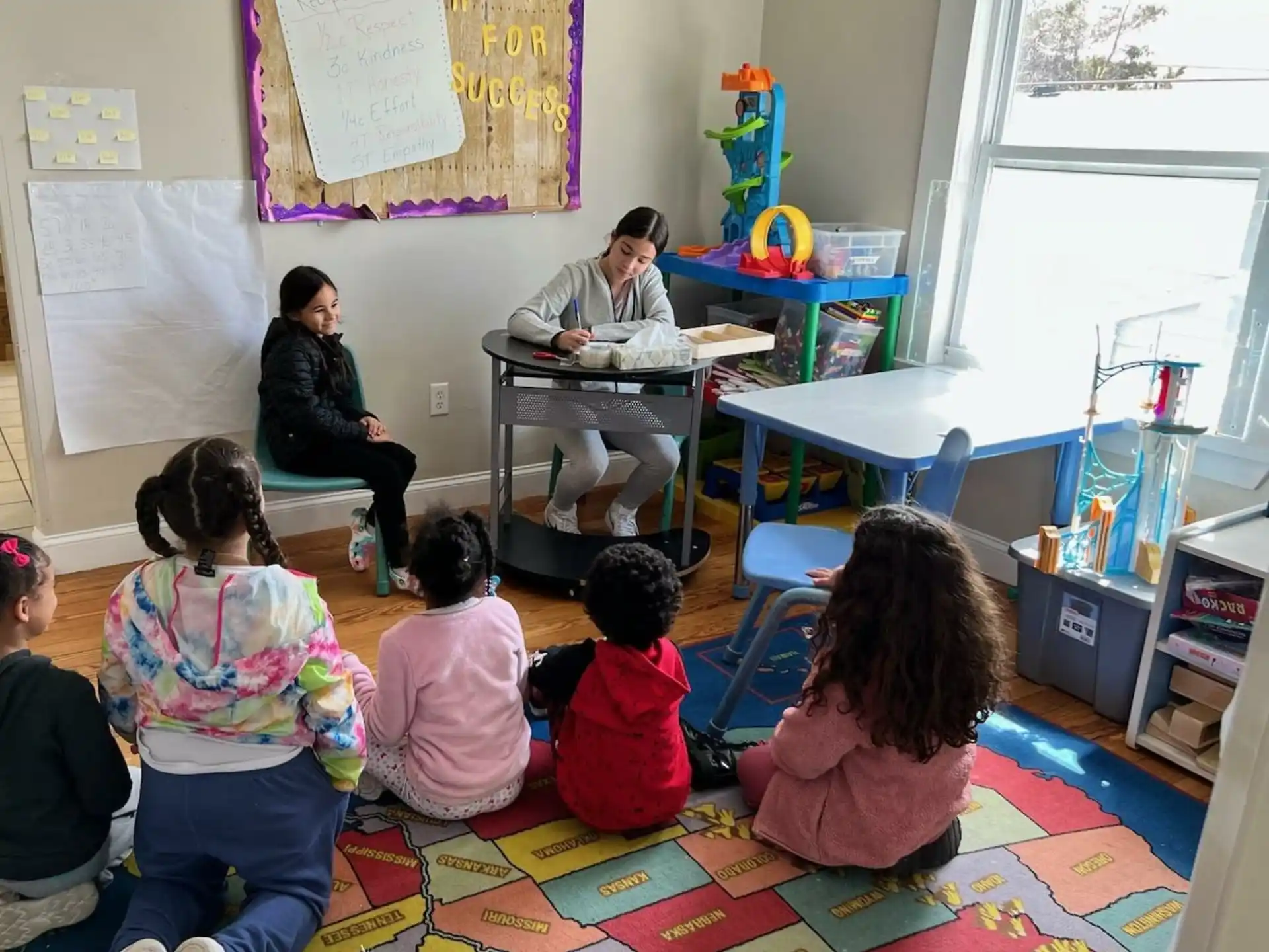 a group of children sitting on the floor in a classroom