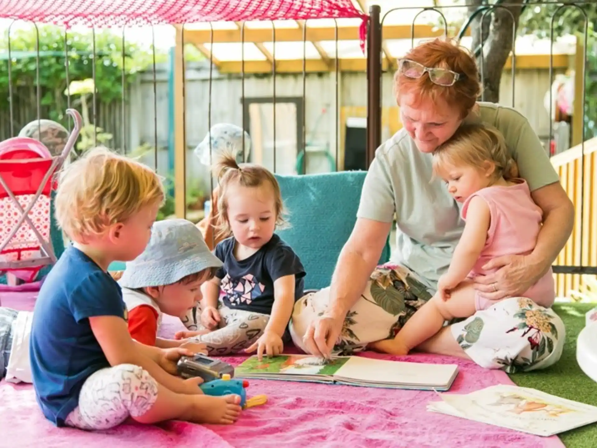 a person and several children sitting on a blanket
