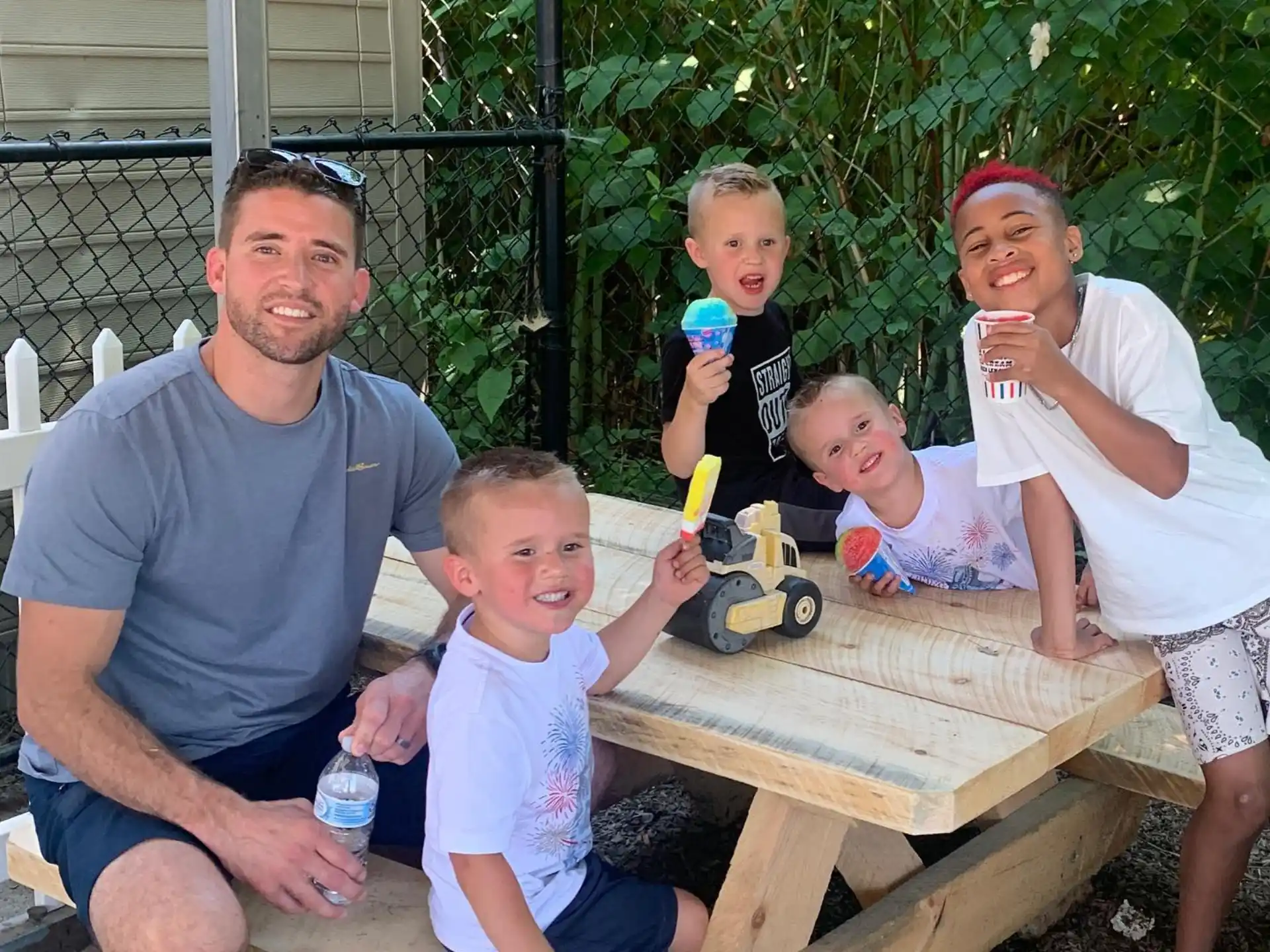 a group of people sitting on a bench with a child and a toy