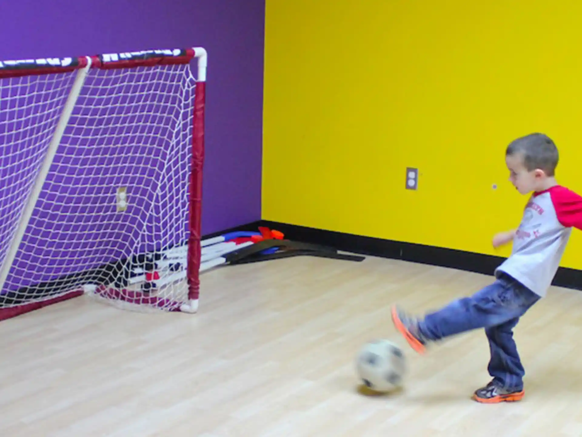 a child kicking a football ball