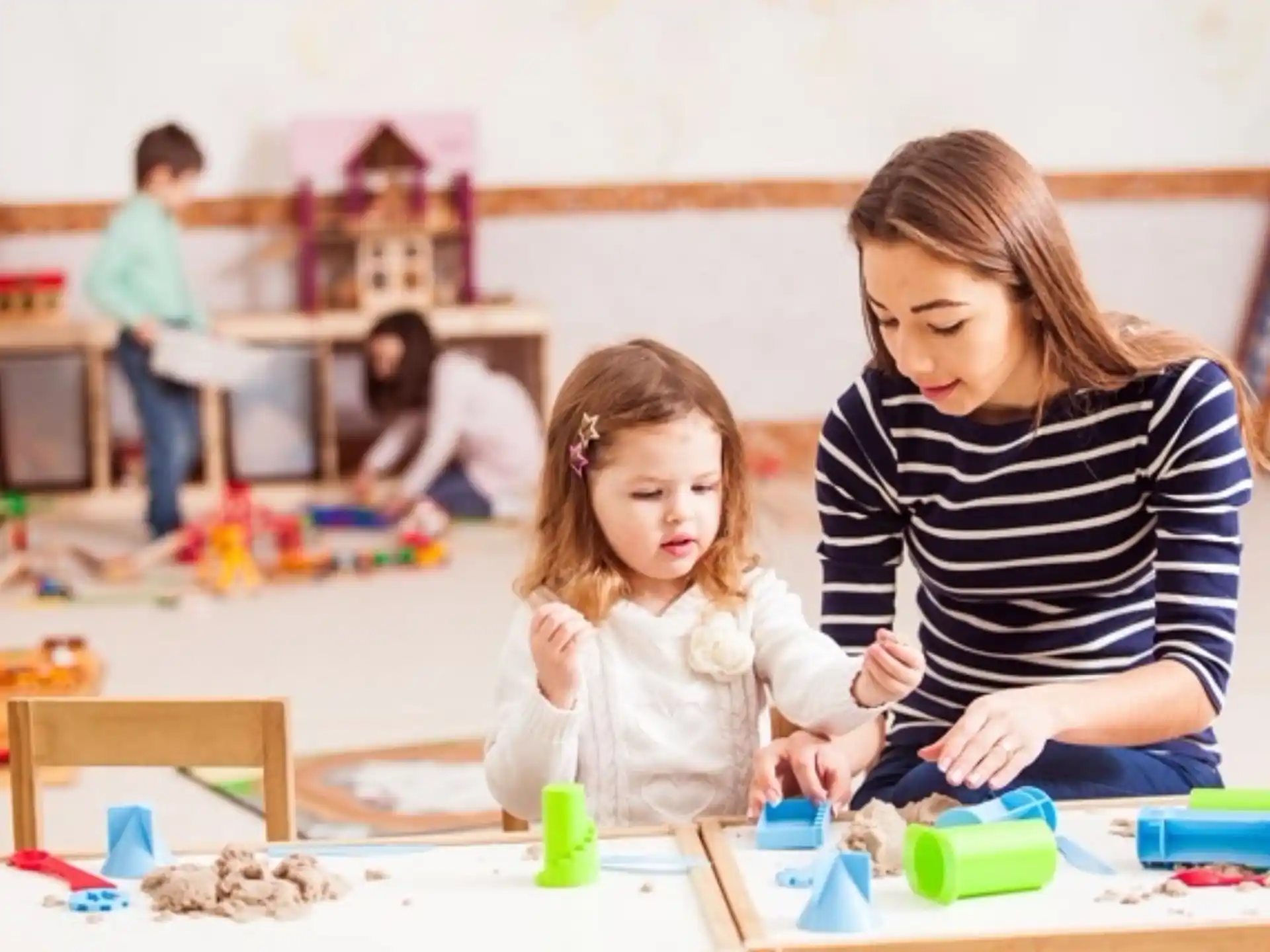 a person and a child playing with toys on the floor