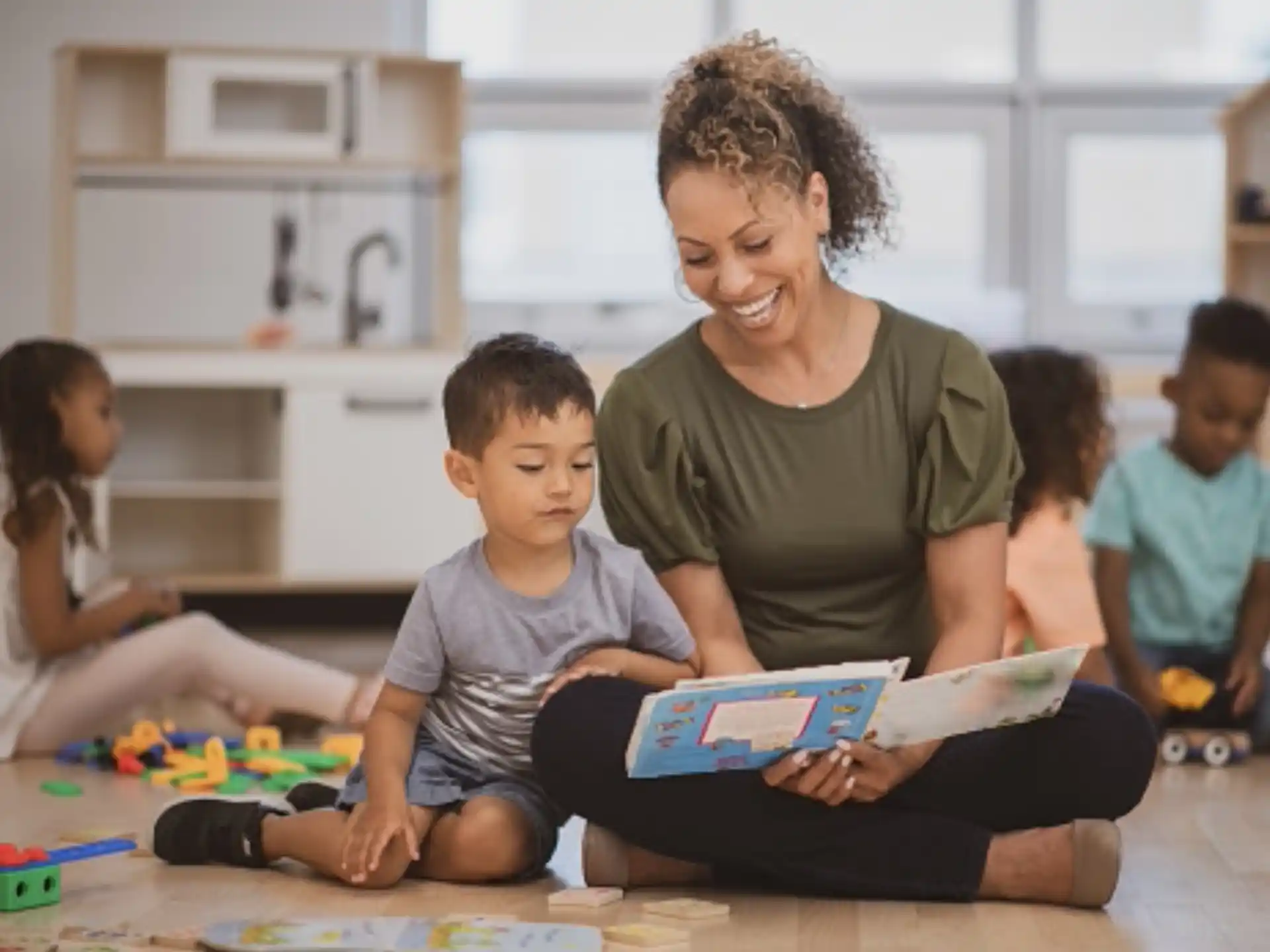 a person reading a book to a group of children