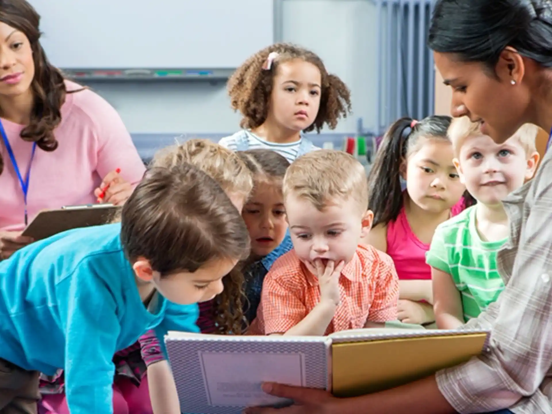 a group of children looking at a book