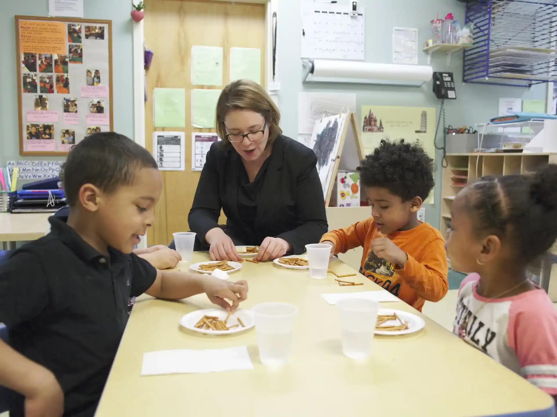 a person and several children eating at a table