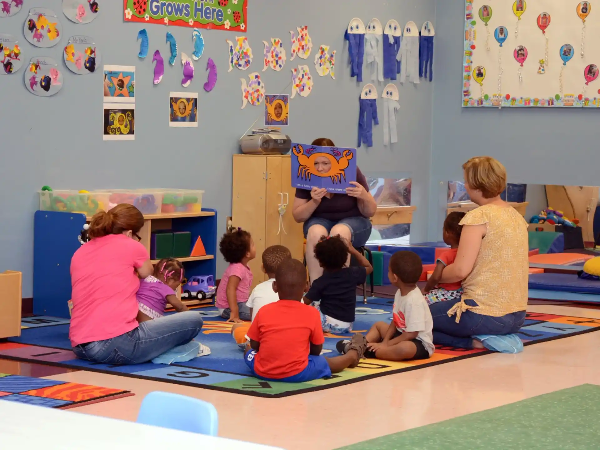 a group of children sitting on the floor in a classroom