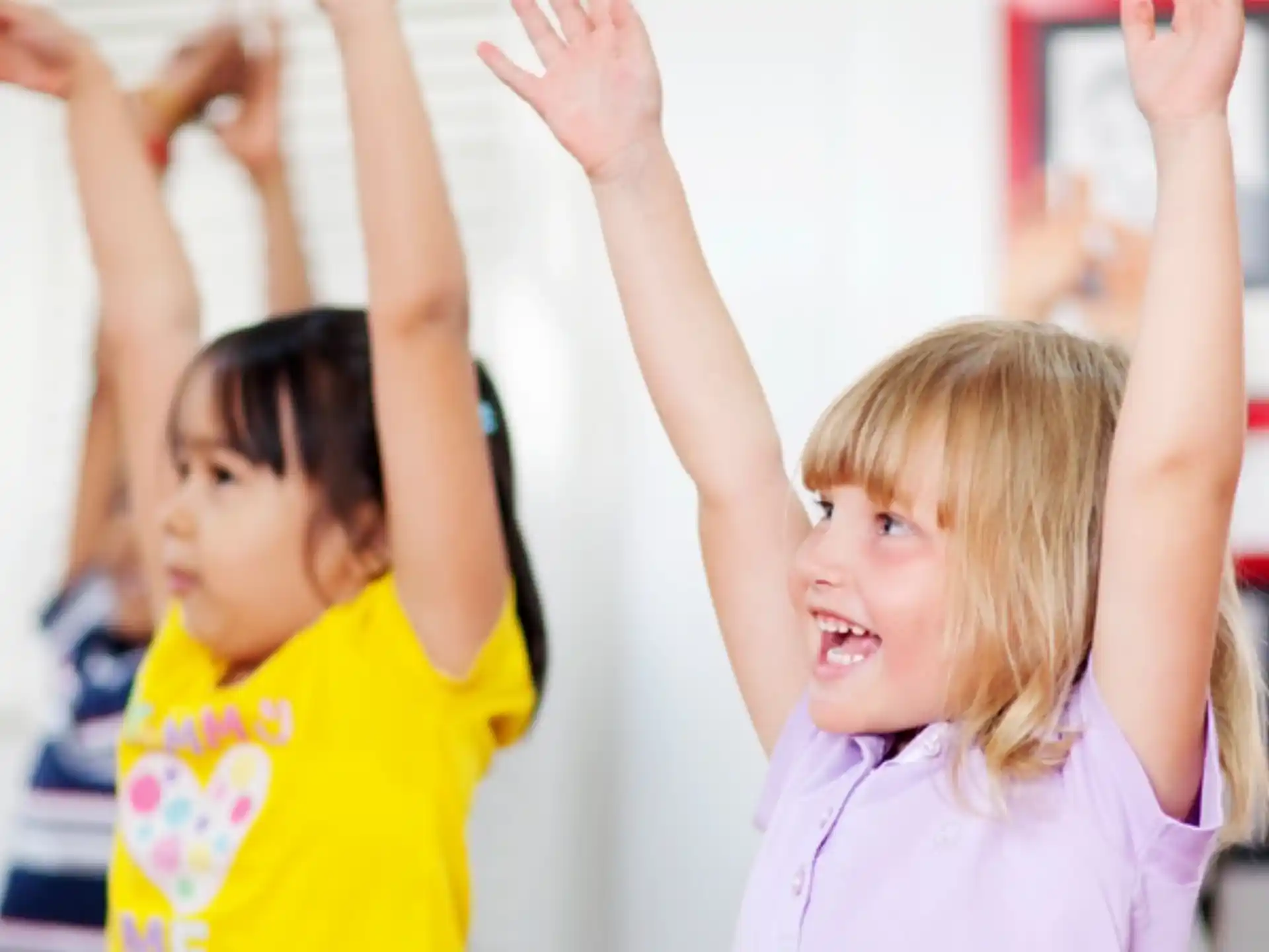 a few young girls raising their hands